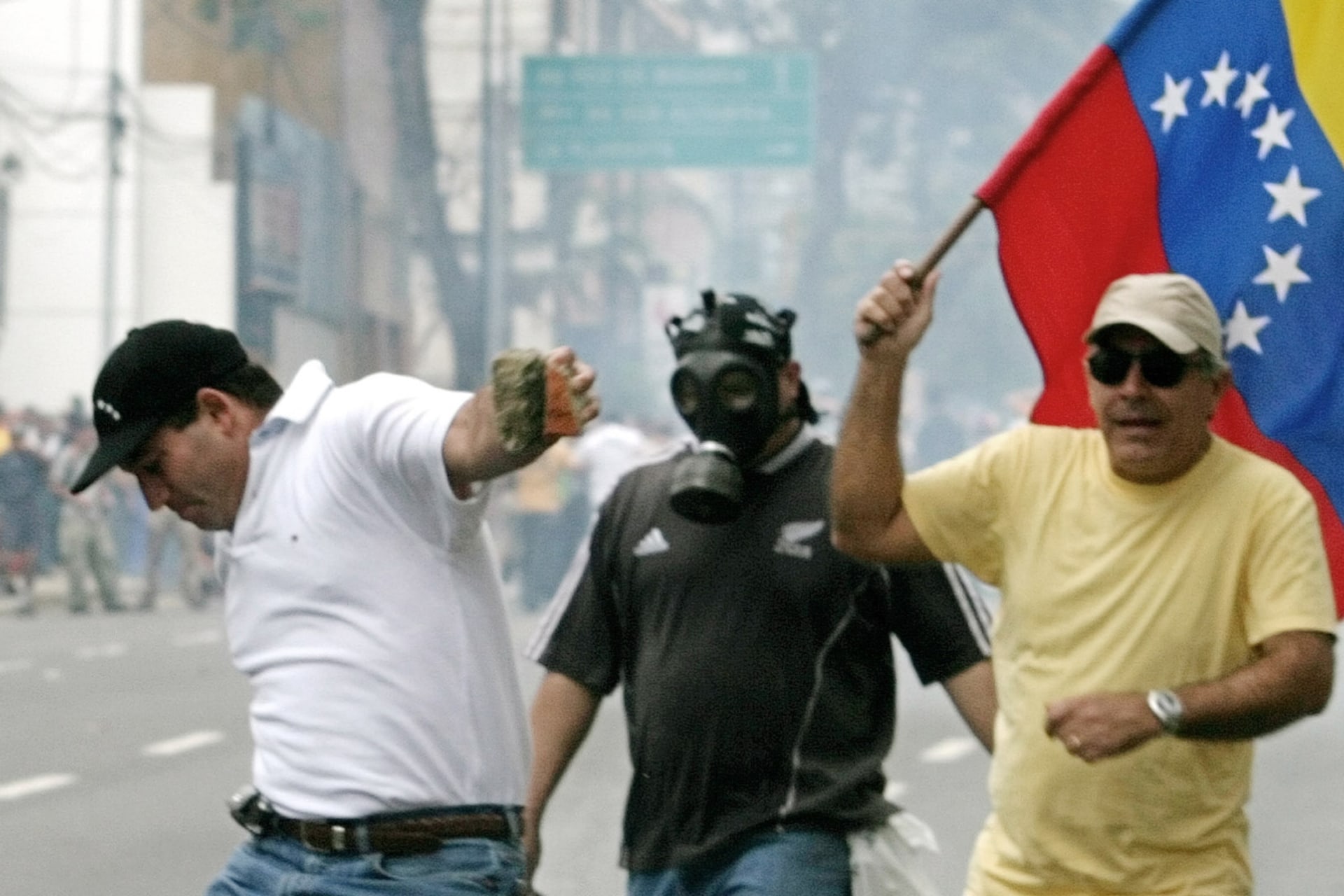 <p>A protester kicks back a tear gas canister during clashes with national guardsmen in Caracas, February 29, 2004.</p>
