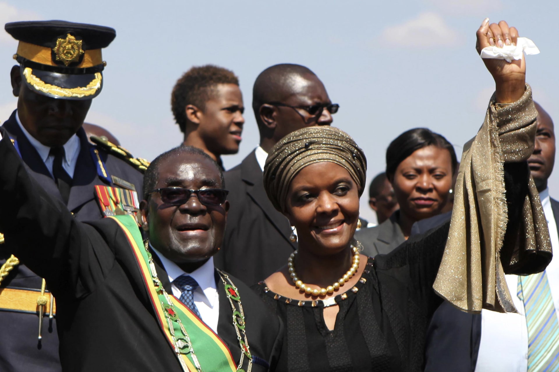 <p>Zimbabwe President Robert Mugabe (L) and his wife Grace (R) greet supporters at a national Heroes Day rally in Harare on August 11, 2014.</p>
