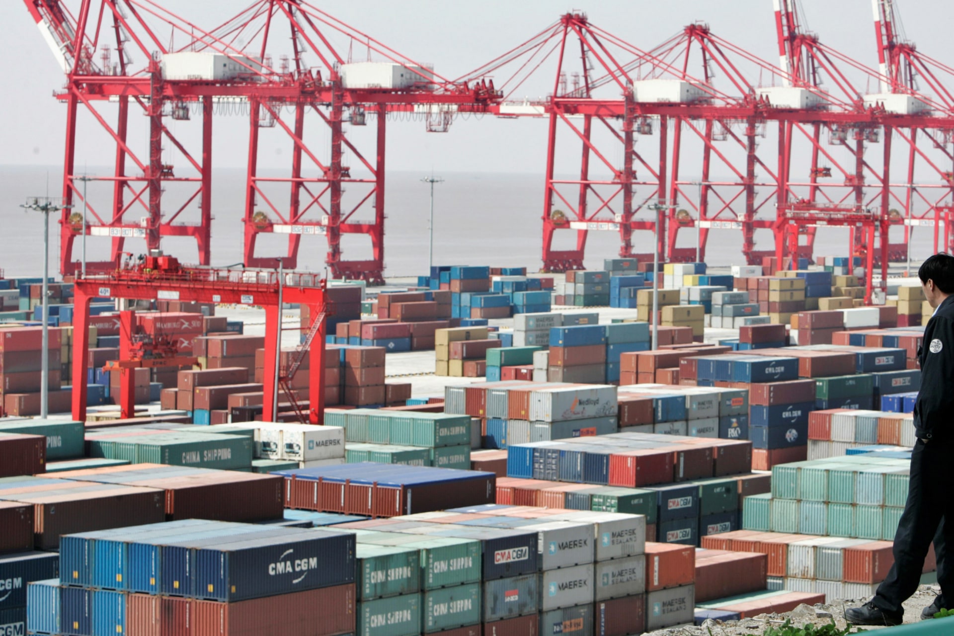 <p>A man watches containers at the Yangshan deepwater port in Shanghai on March 7, 2007.</p>
