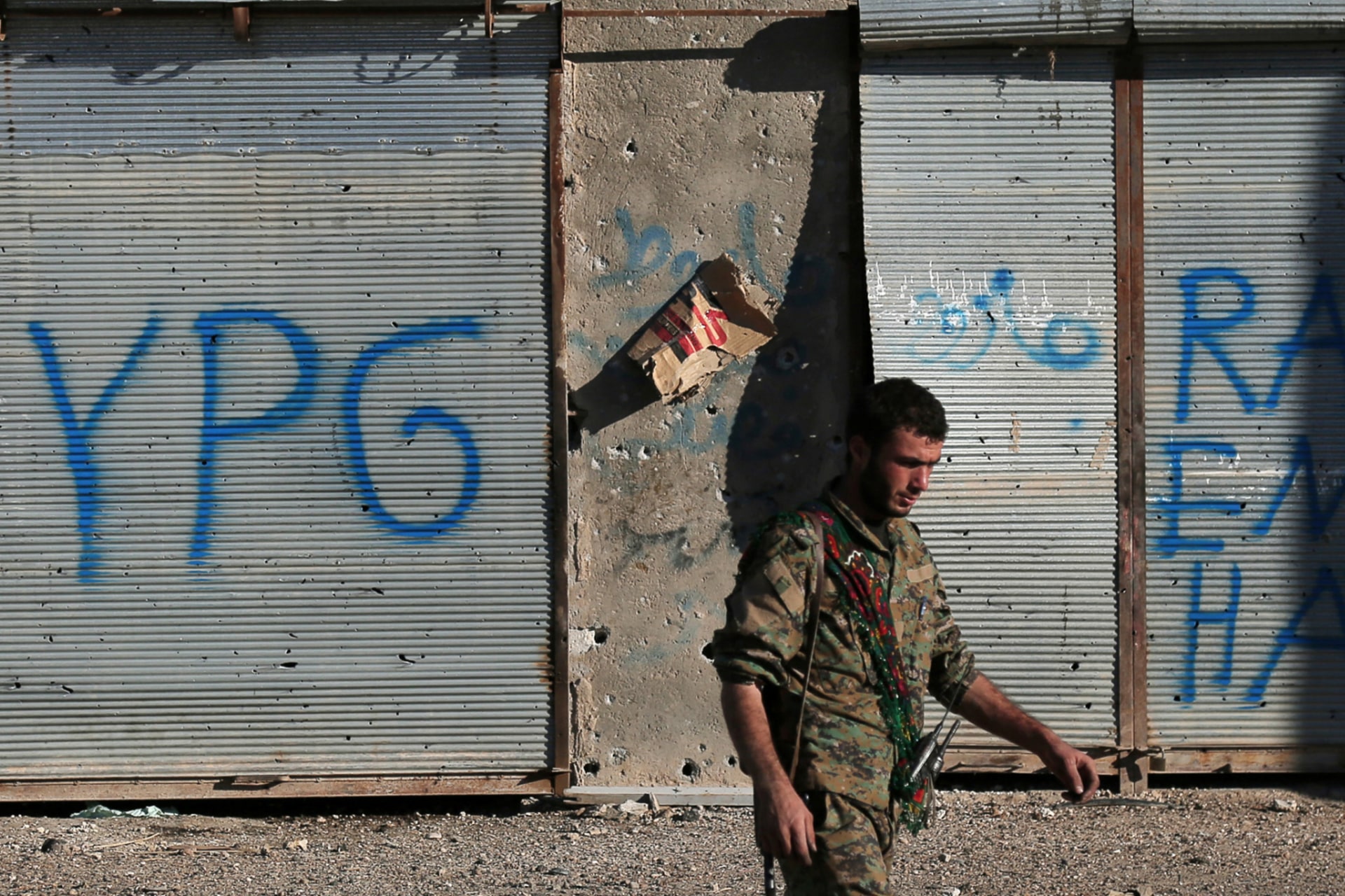 <p>A Syrian Democratic Forces (SDF) fighter walks in Tal Samin village, north of Raqqa city, Syria on November 19, 2016.</p>
