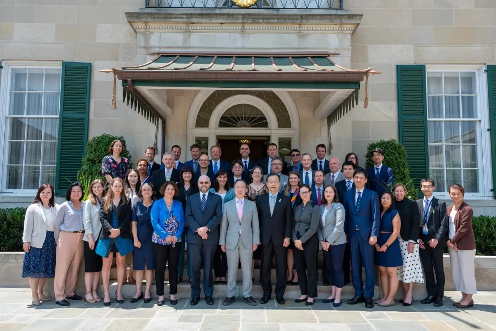 Photo of a group of people standing infront of a marble building.