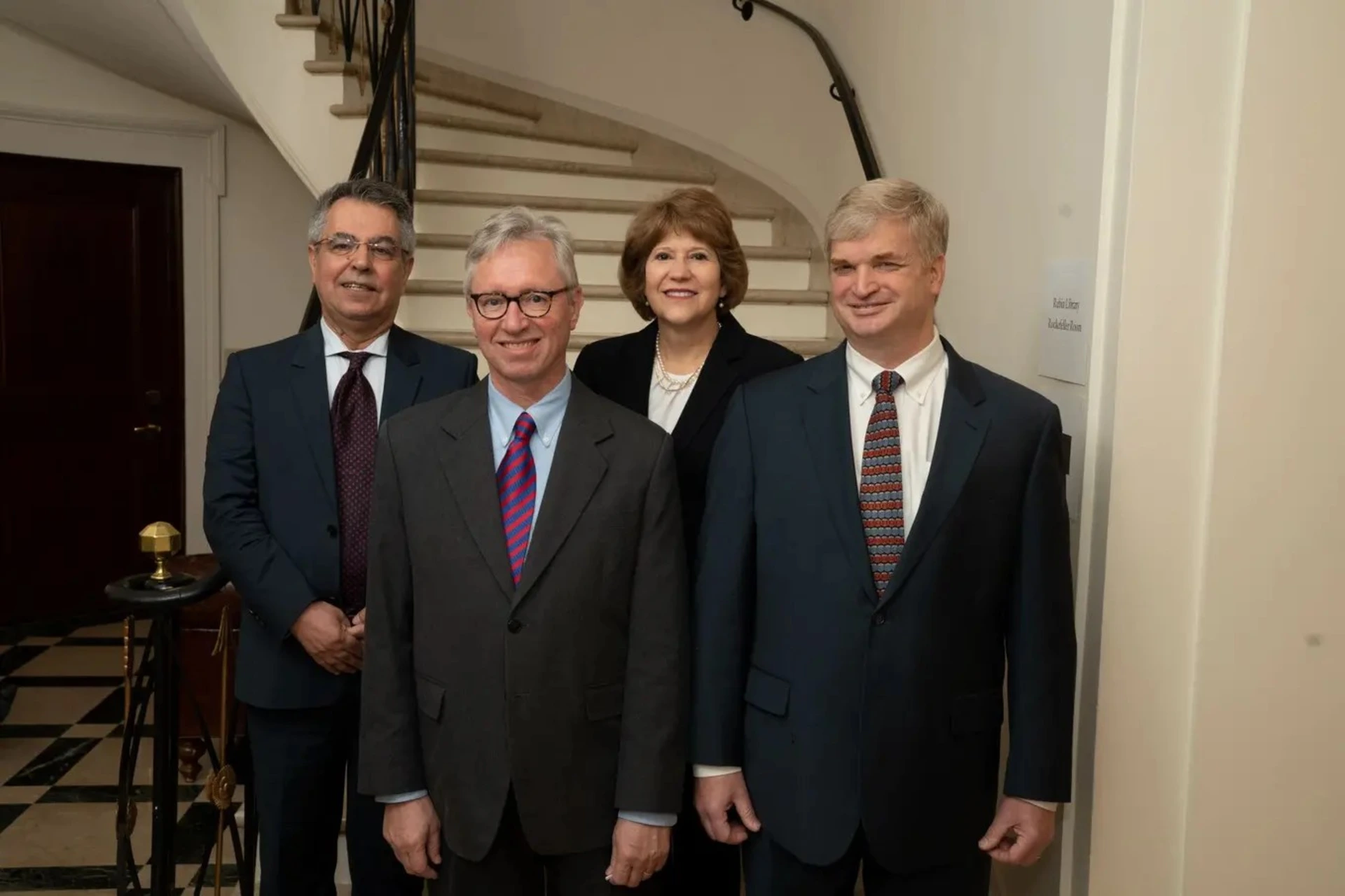 Photo of four people at the bottom of a marble spiral staircase.
