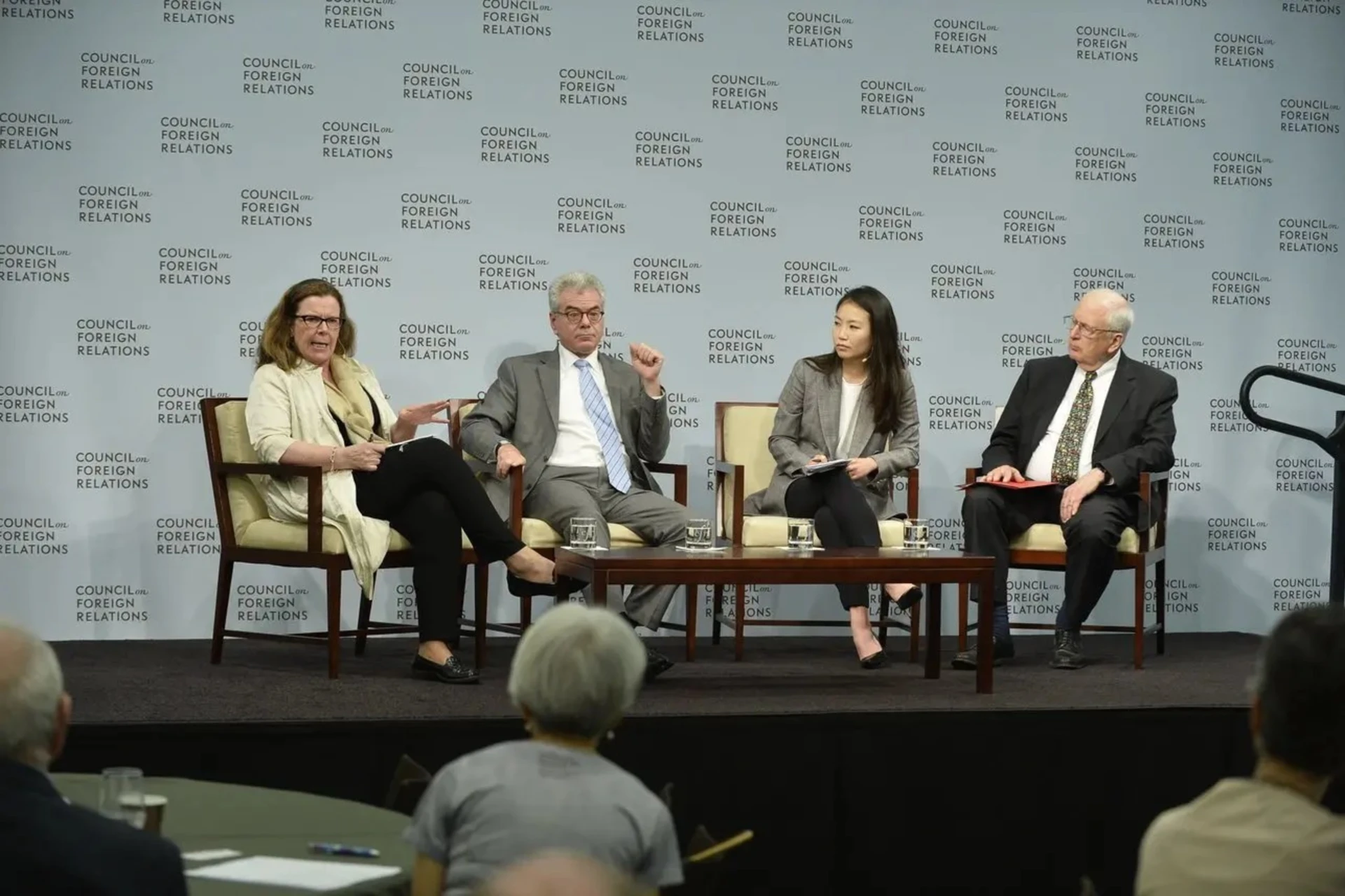 Photo of a panel of four people sitting on a raised stage.