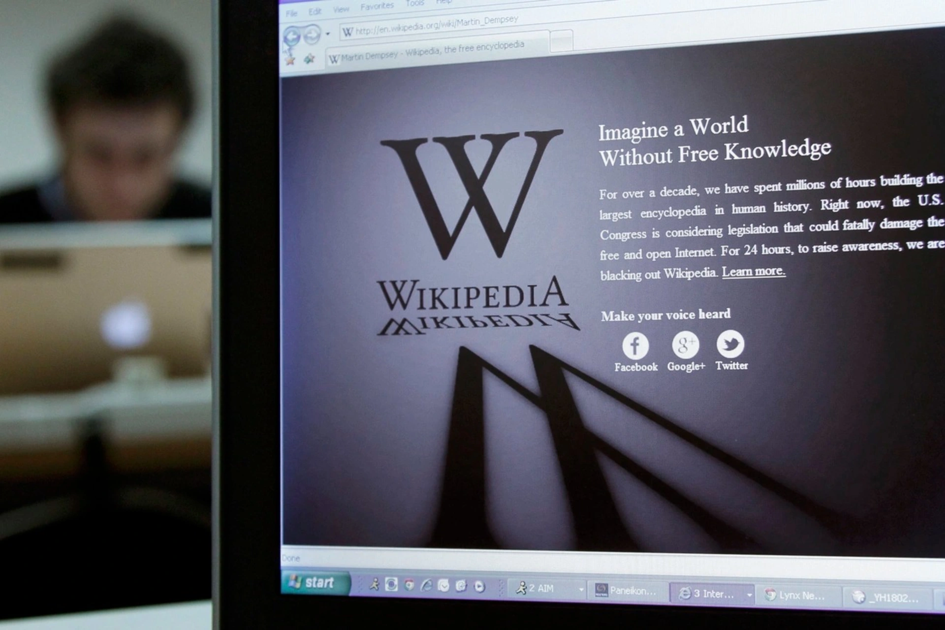 A reporter's laptop shows the Wikipedia blacked out opening page. 