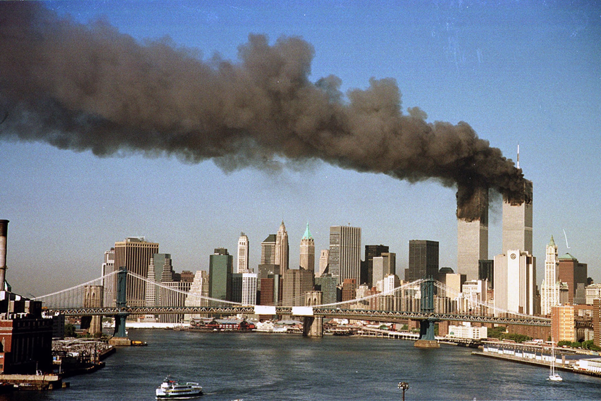 The towers of New York City’s World Trade Center billow smoke after being struck by hijacked commercial airplanes.