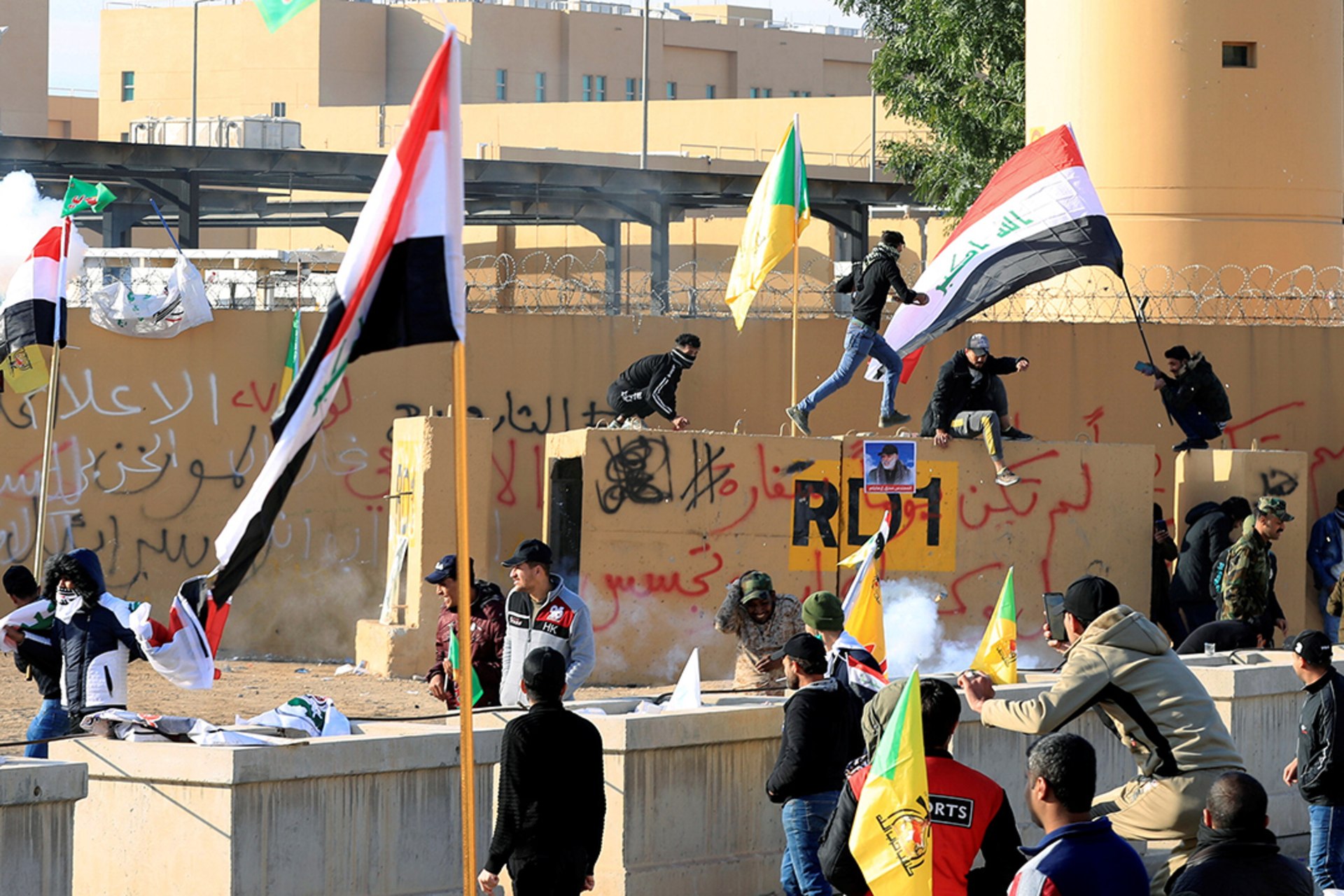 Security guards use stun grenades to disperse protesters and militia fighters during an attack on the U.S. embassy in Baghdad.