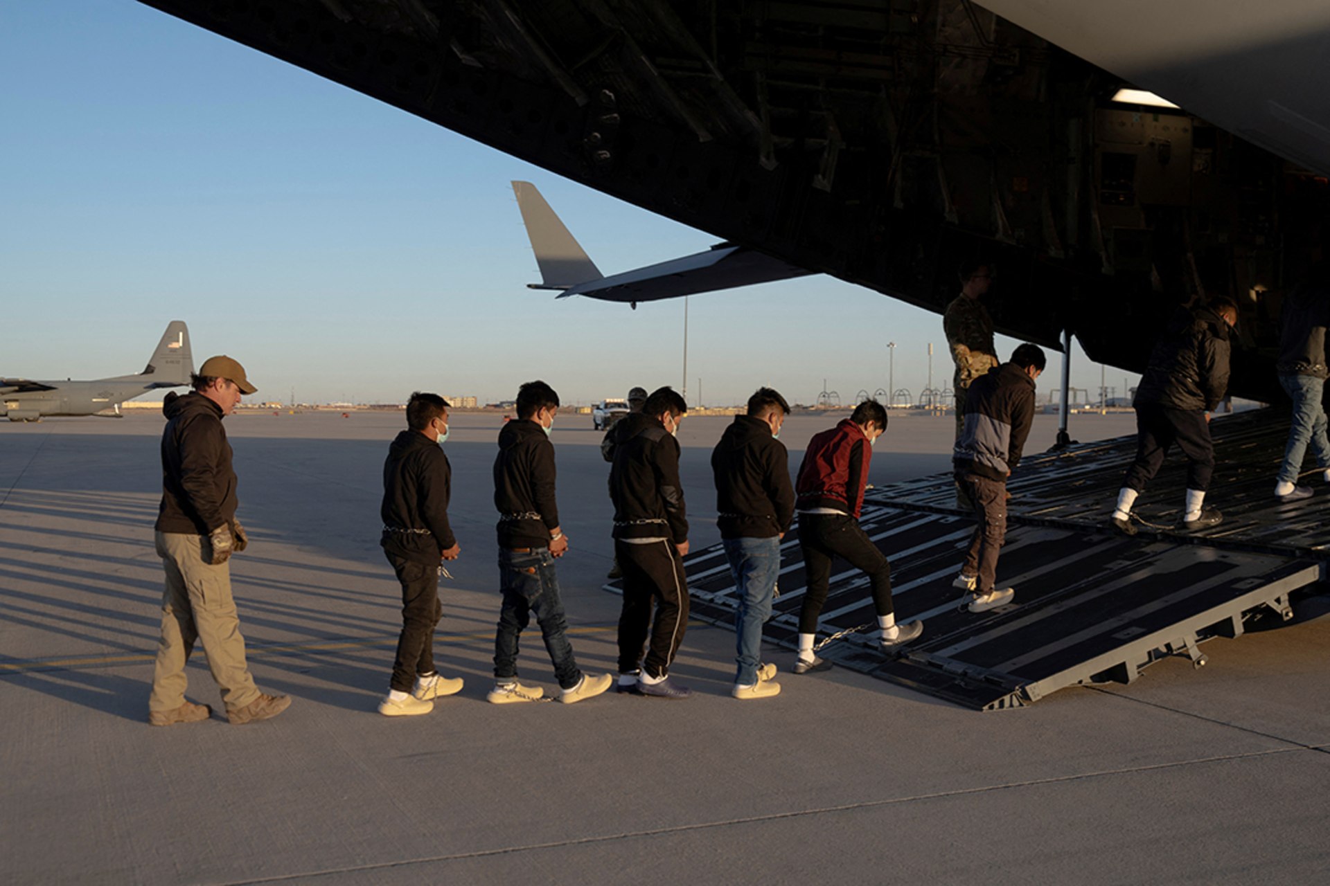 Customs and Border Protection agents guide detained migrants aboard a U.S. aircraft at Fort Bliss, Texas. DoD/Handout/Reuters