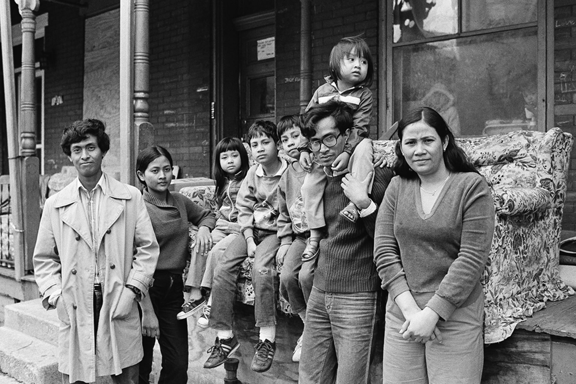 A resettled Cambodian refugee family stands outside their home in Pennsylvania. Paul Vathis/AP Images