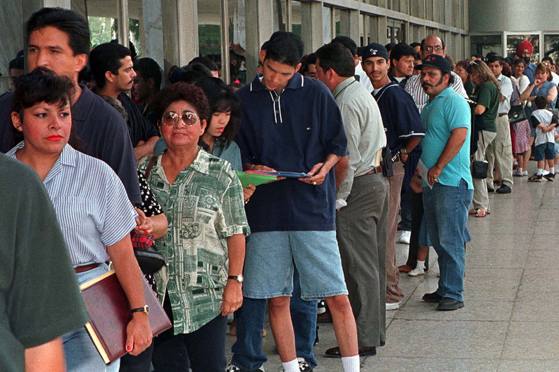 Immigrants stand in line outside the INS office. Fred Prouser/Reuters