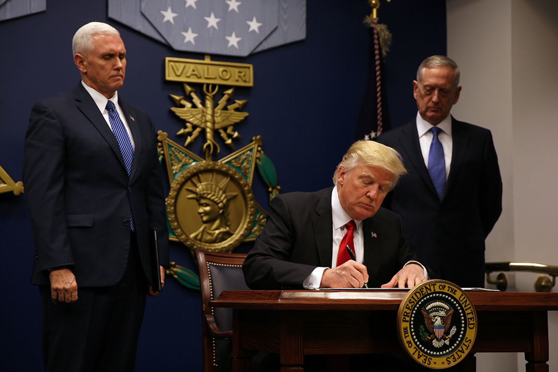 President Donald J. Trump signs an executive order on new immigration restrictions. Carlos Barria/Reuters