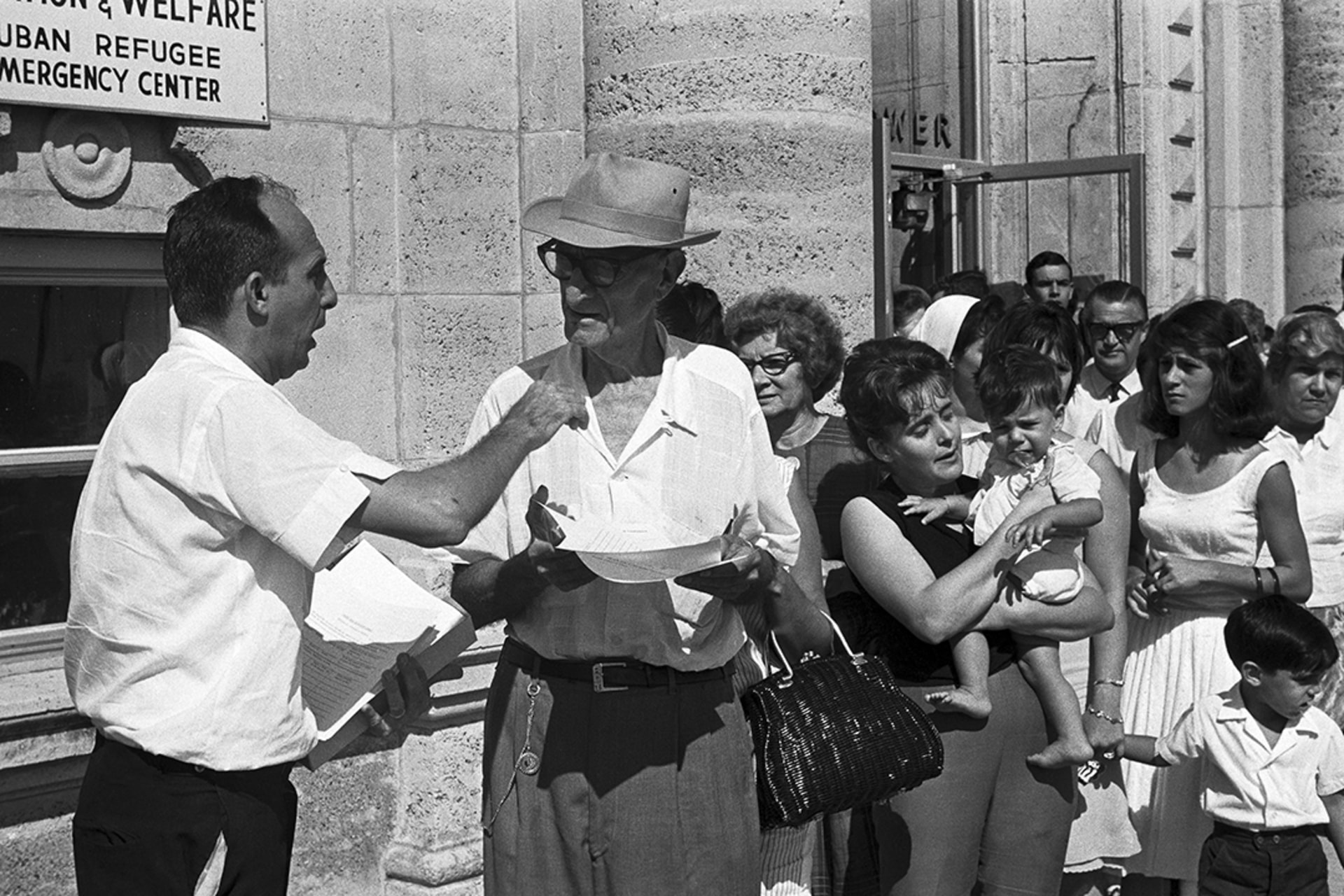 A refugee worker hands out forms to Cubans waiting at the Cuban Refugee Emergency Center in Miami.