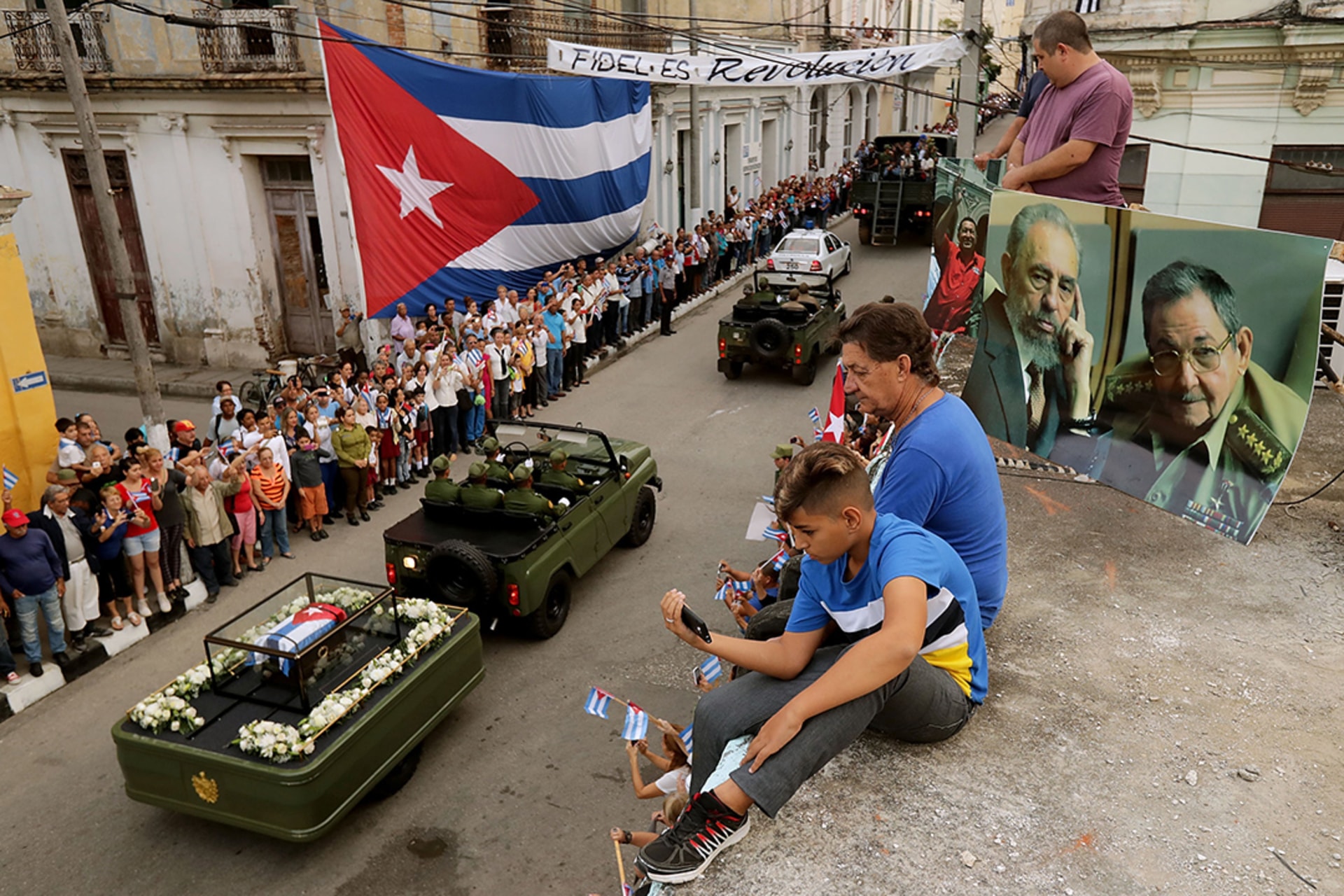 People watch as a military vehicle holding Fidel Castro’s remains passes through Havana, Cuba.
