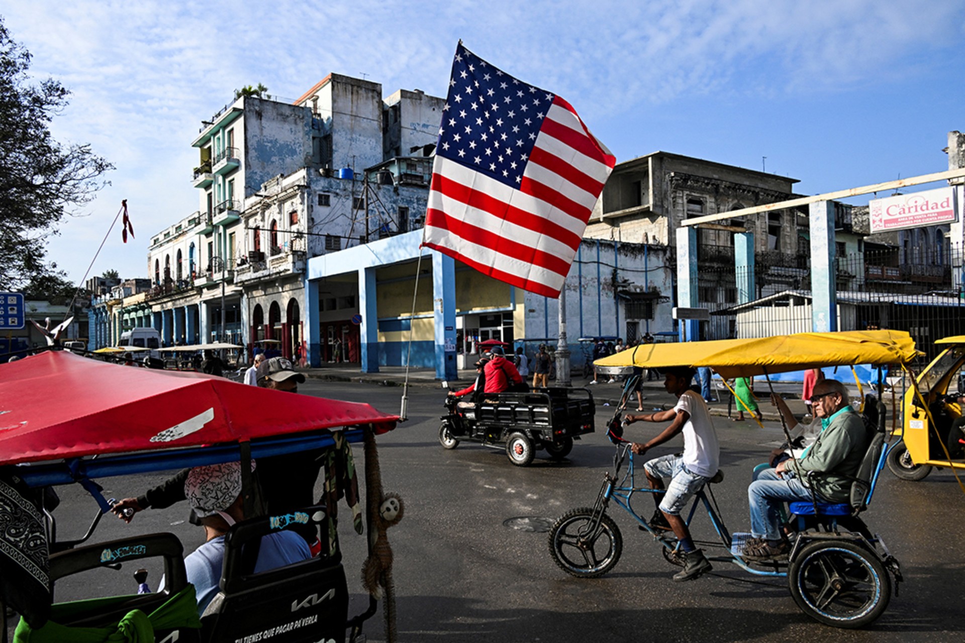 A tricycle being used as a taxi in Havana, Cuba, is decorated with the U.S. flag, January 21, 2025.