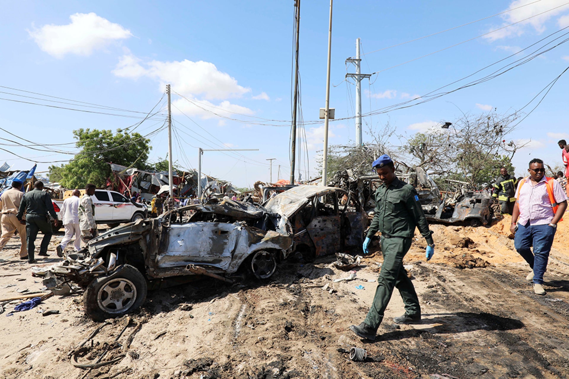 A Somali police officer walks past wreckage at the scene of a car bombing in Mogadishu in December 2019.