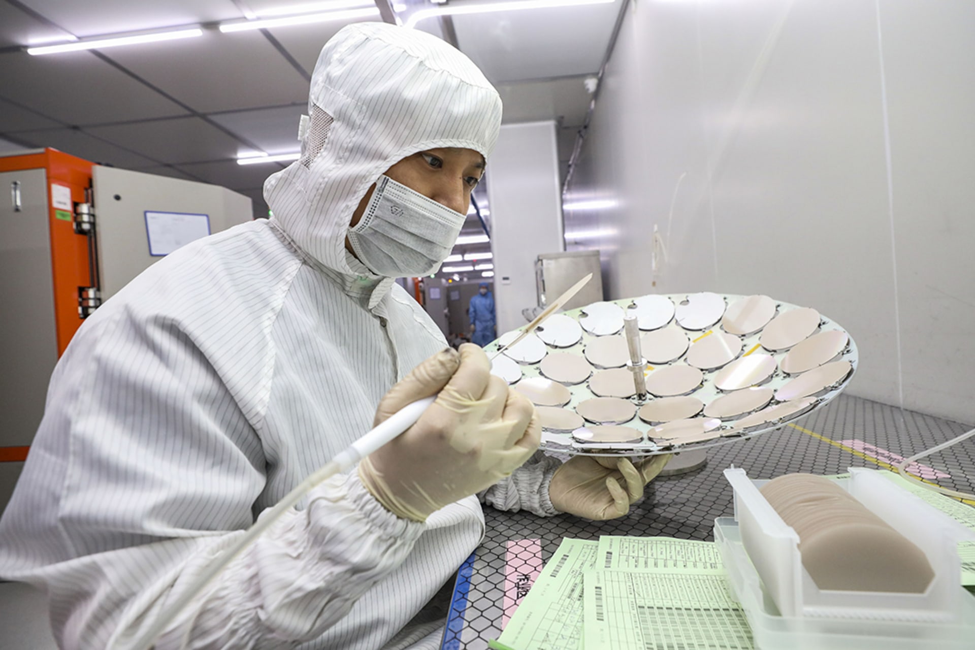 An employee works on a production line for semiconductor wafers at a factory in Huai’an, China. 
