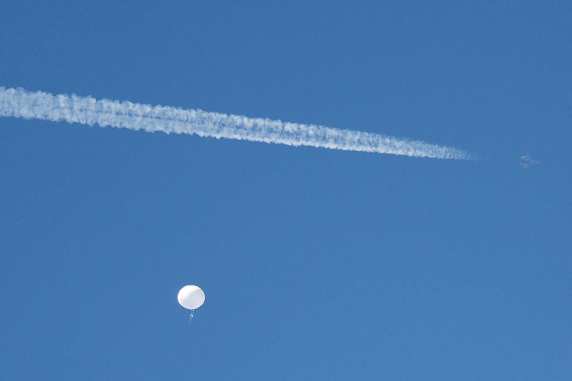 A U.S. fighter jet flies by the suspected spy balloon as it floats off the coast of South Carolina, on February 4, 2023.