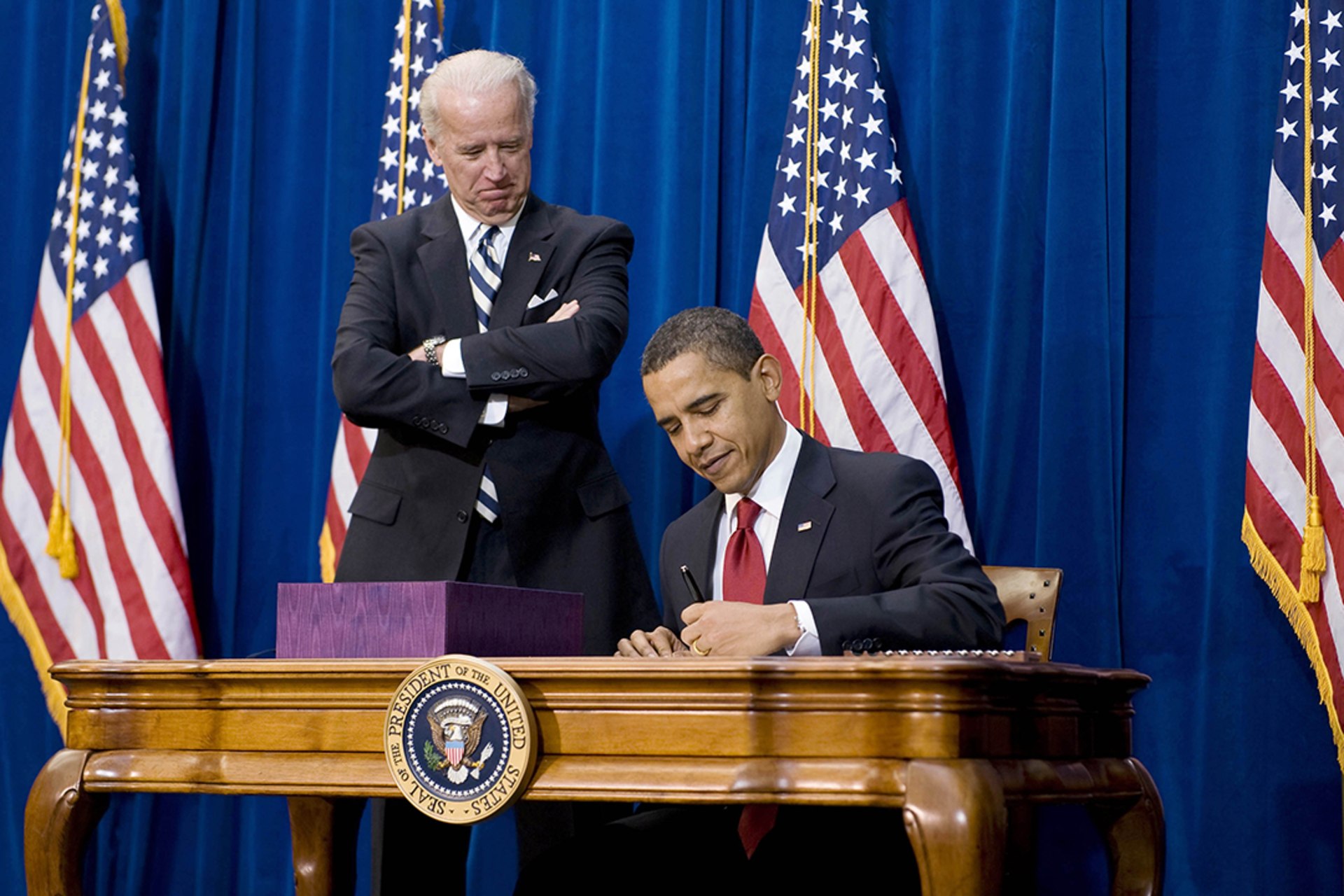 President Barack Obama, alongside Vice President Joseph Biden, signs the American Recovery and Reinvestment Act on February 17, 2009.