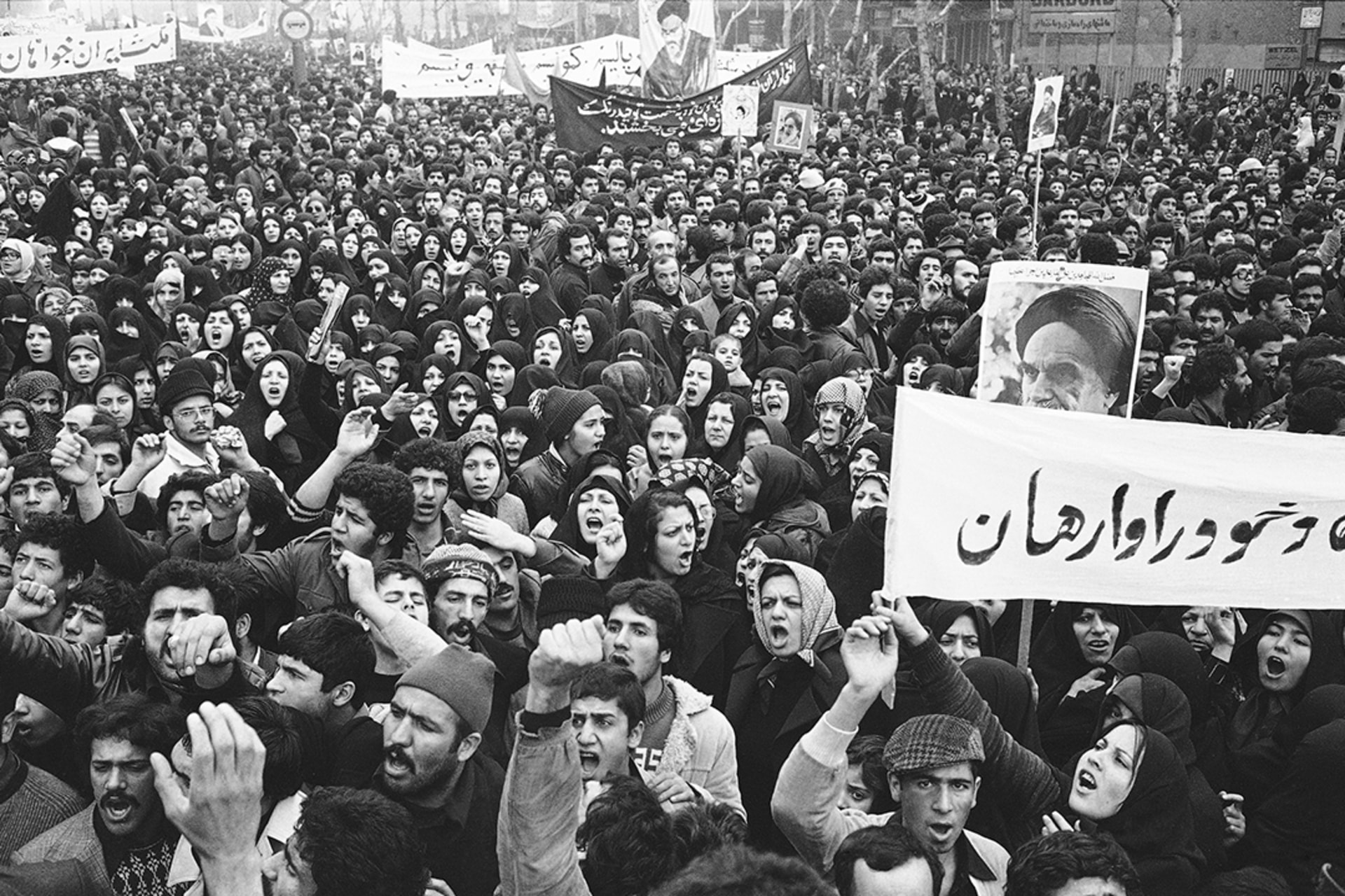 A poster of exiled Muslim leader Ayatollah Khomeini is carried by marchers with clenched fists during the anti-Shah demonstrations in Tehran, December 11, 1978.