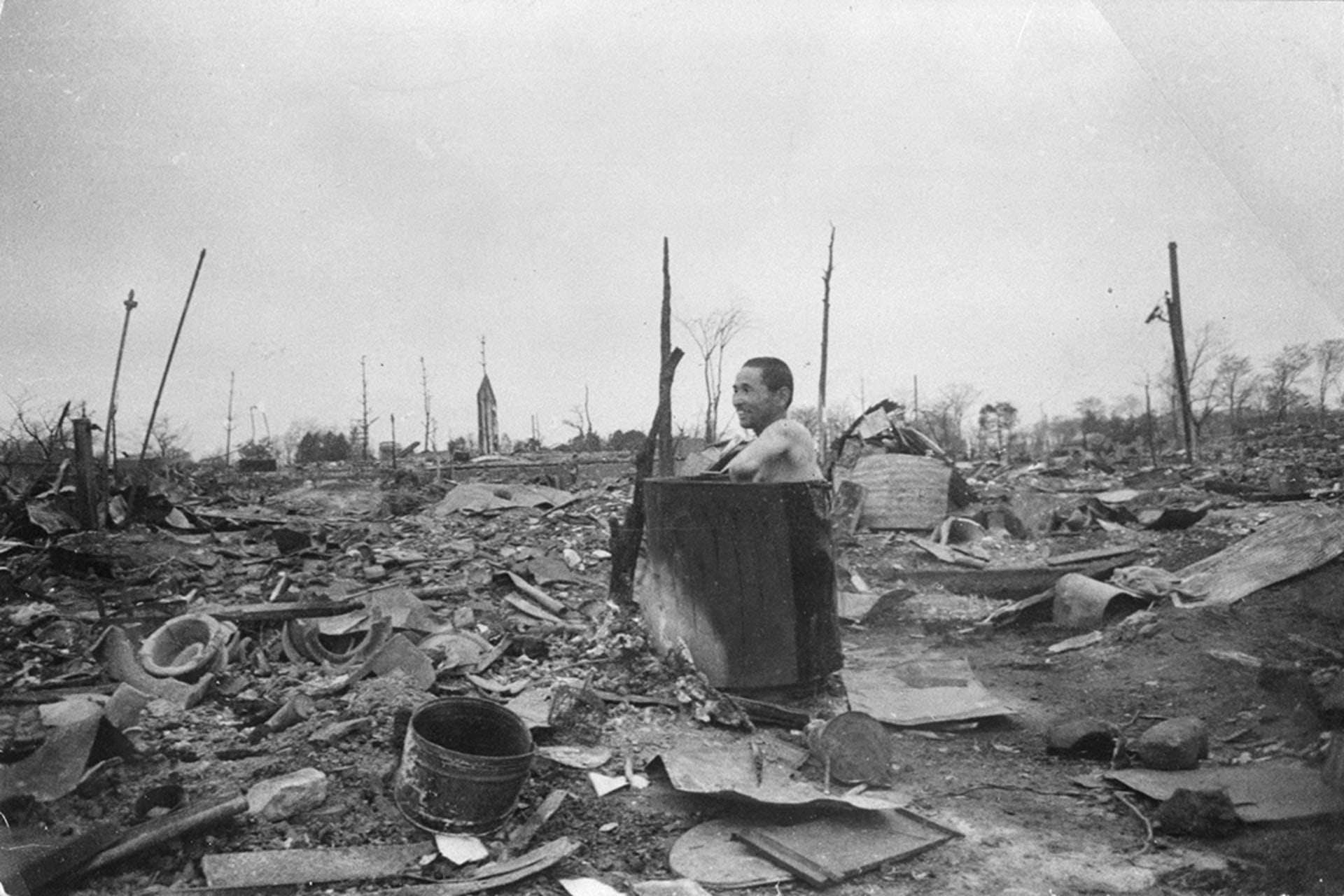 A man bathes amid the rubble of Tokyo. 

