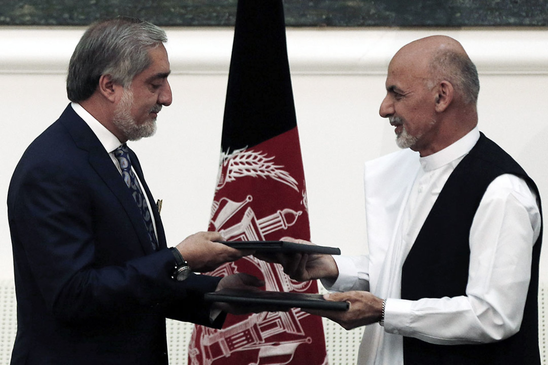 Abdullah Abdullah and Ashraf Ghani exchange signed agreements to form a unity government. 
