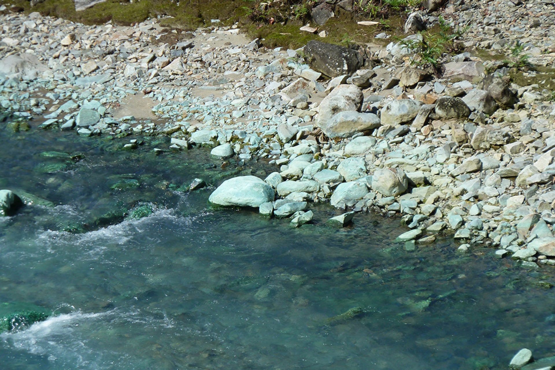 The Jaba River is still contaminated by mine runoff that has turned the river bed copper blue, May 2010.