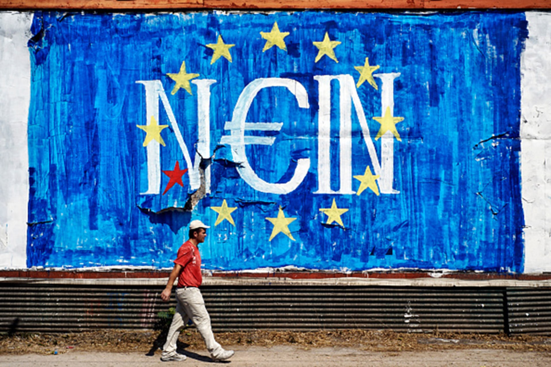 A man walks past anti-EU graffiti in Athens. 