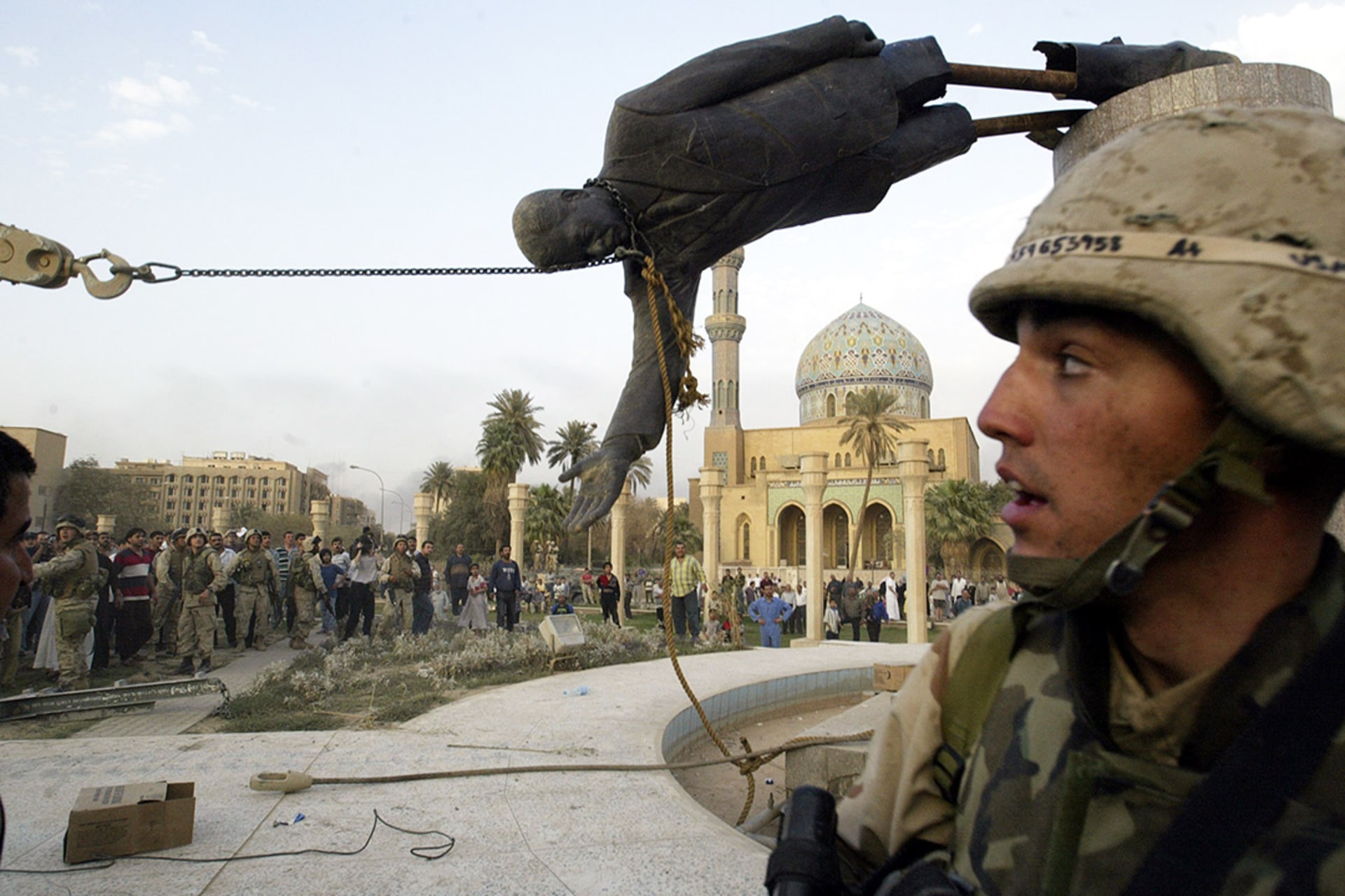 We Iraqi civilians and U.S. soldiers pull down a statue of Saddam Hussein in Baghdad. 
