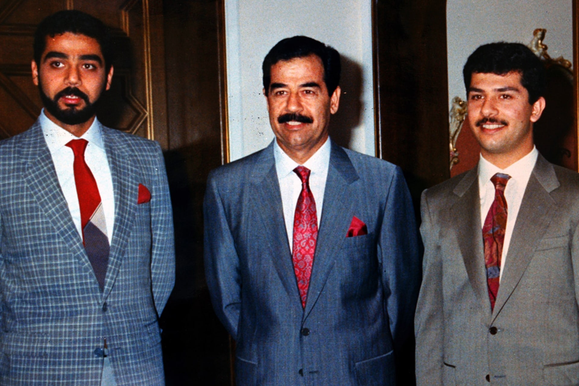 Saddam poses with his sons Uday and Qusay.