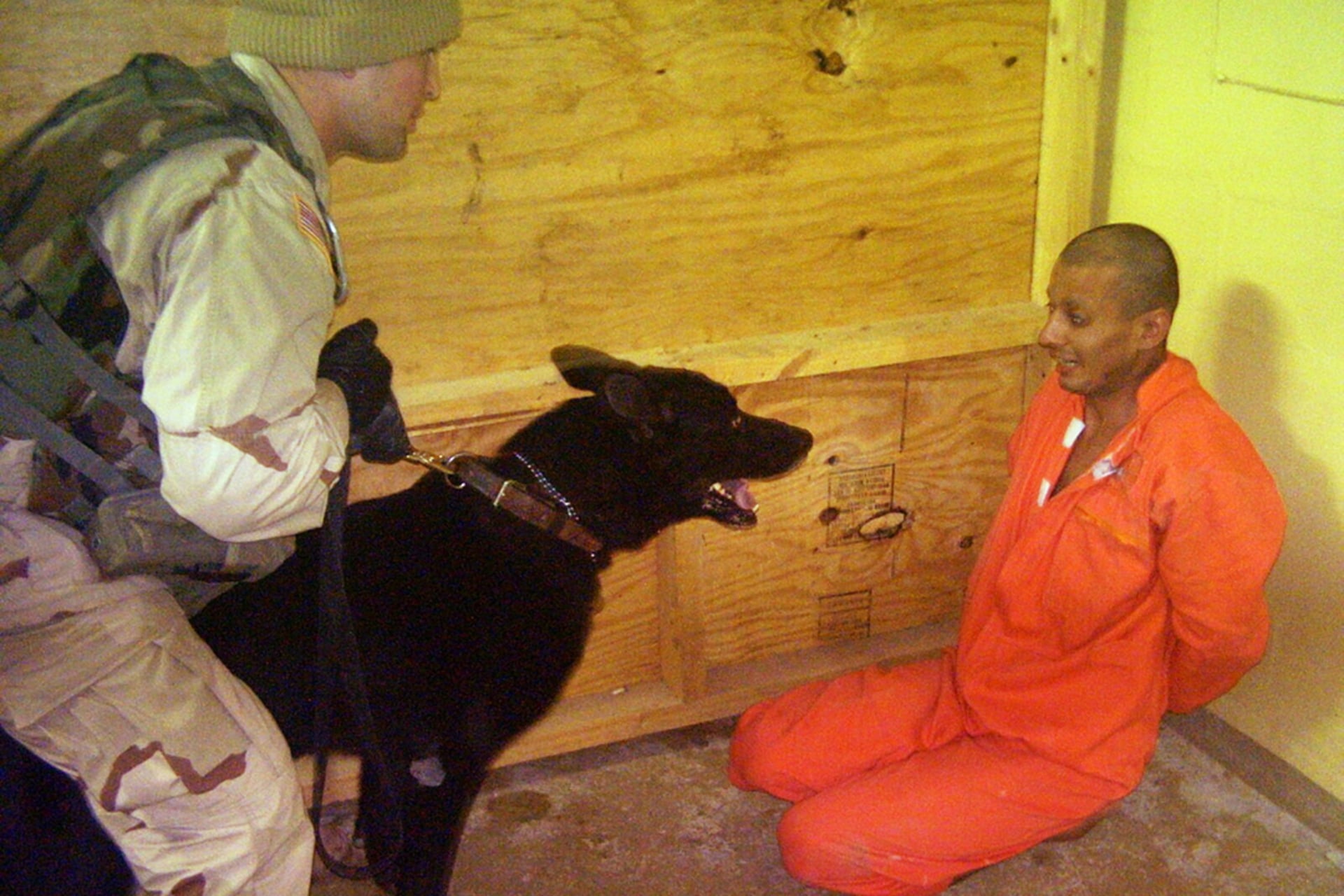 Sergeant Michael Smith and his dog intimidate a detainee at Abu Ghraib in Baghdad.
