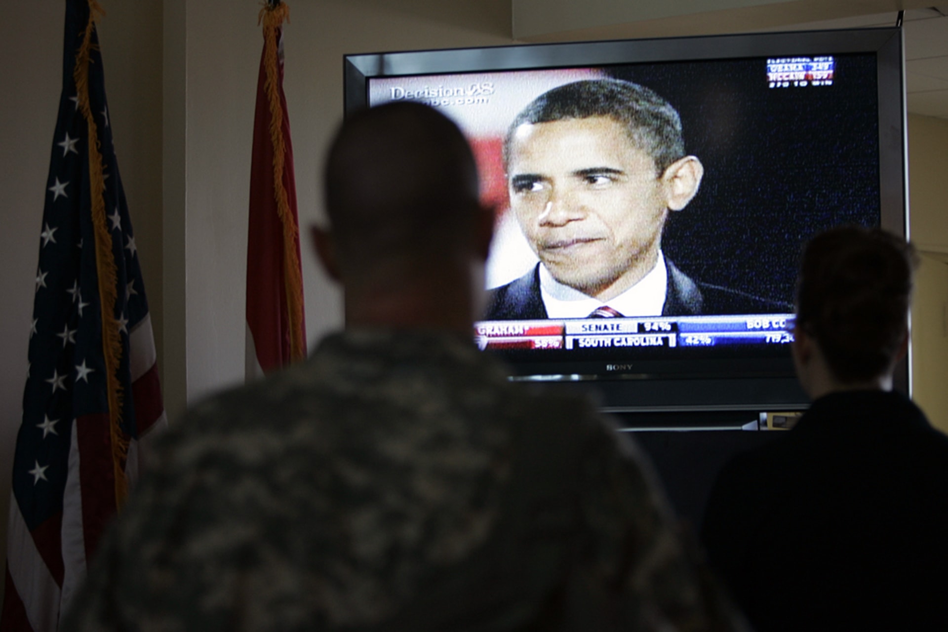 U.S. personnel watch President-Elect Barack Obama on television at the U.S. embassy in Baghdad.