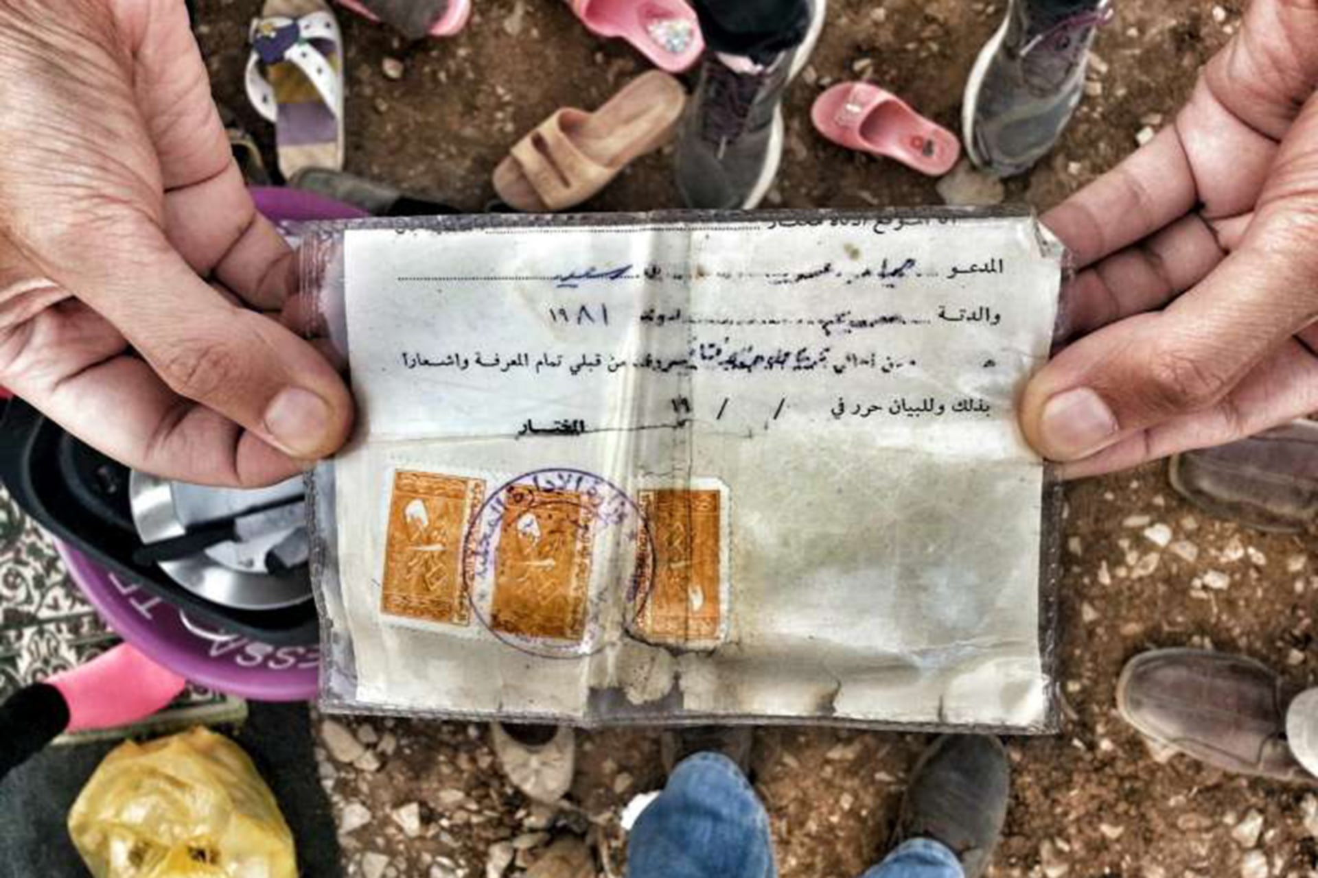 A Syrian refugee shows his “maktoumeen” card, which confers no rights or status and was issued to unregistered stateless Kurds.
