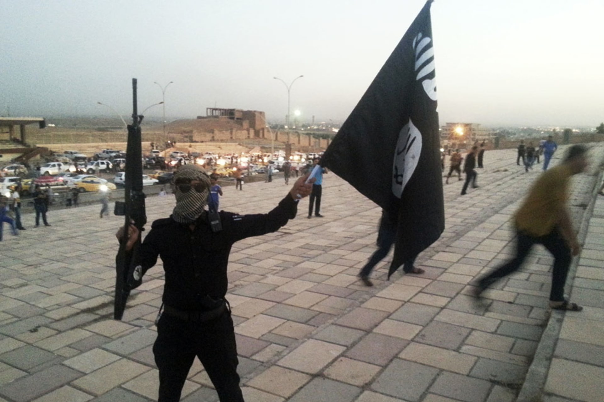 An Islamic State fighter holds a flag bearing the group’s symbol on the streets of Mosul, Iraq, on June 23, 2014.
