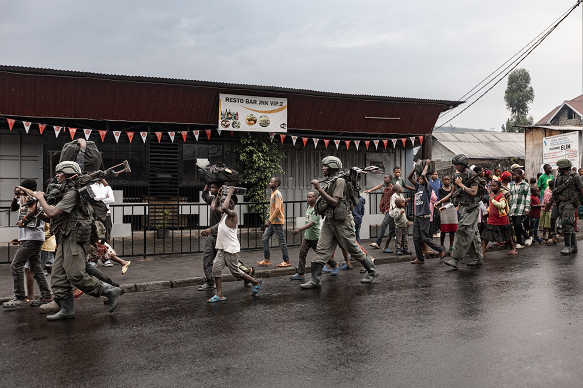 Members of the M23 armed group walk through a street of the Keshero neighborhood in Goma, as residents flee. STR/AFP/Getty Images