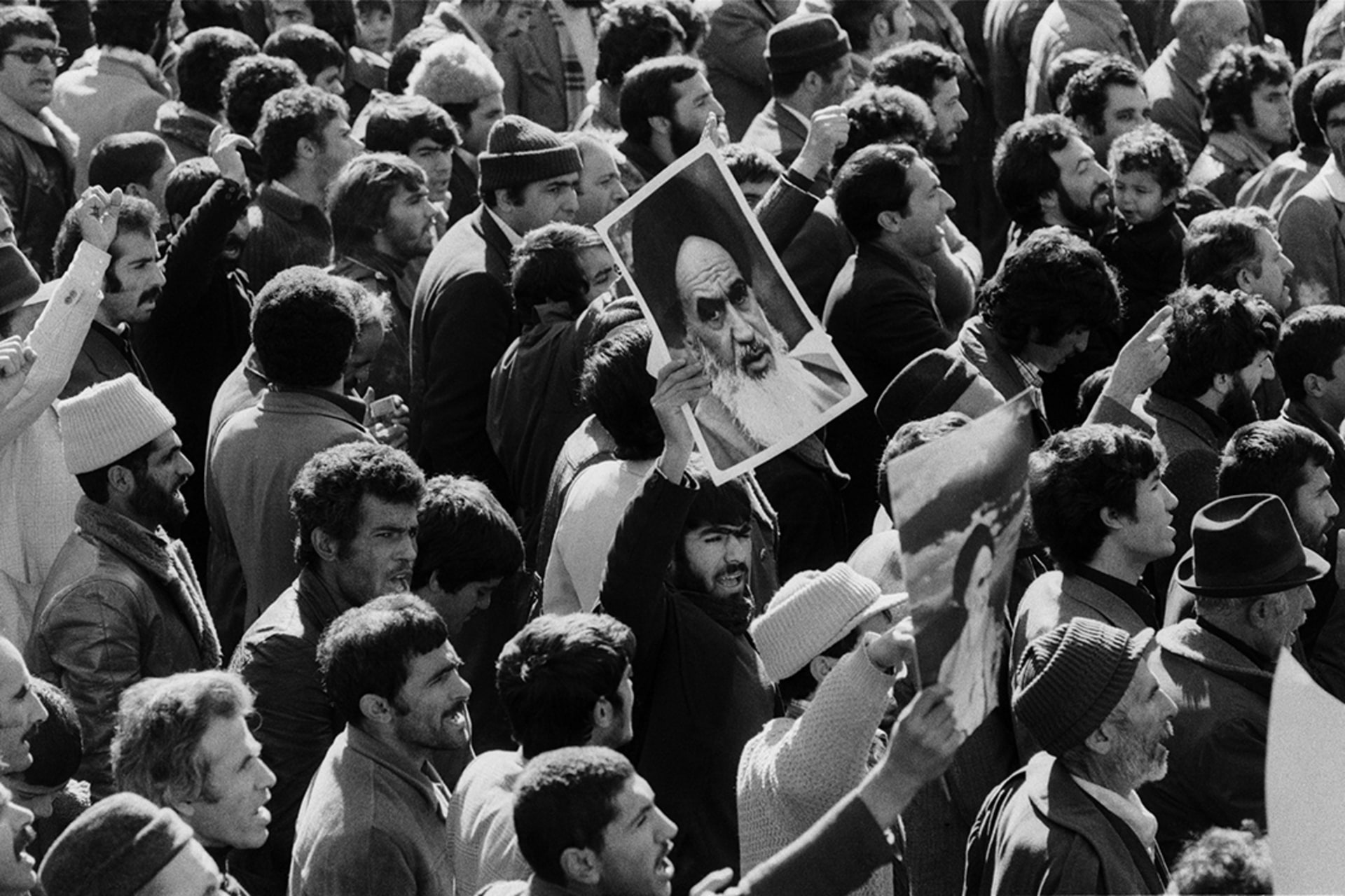 A demonstrator in Tehran carries a portrait of Grand Ayatollah Ruhollah Khomeini, who leads the Iranian Revolution from Paris.