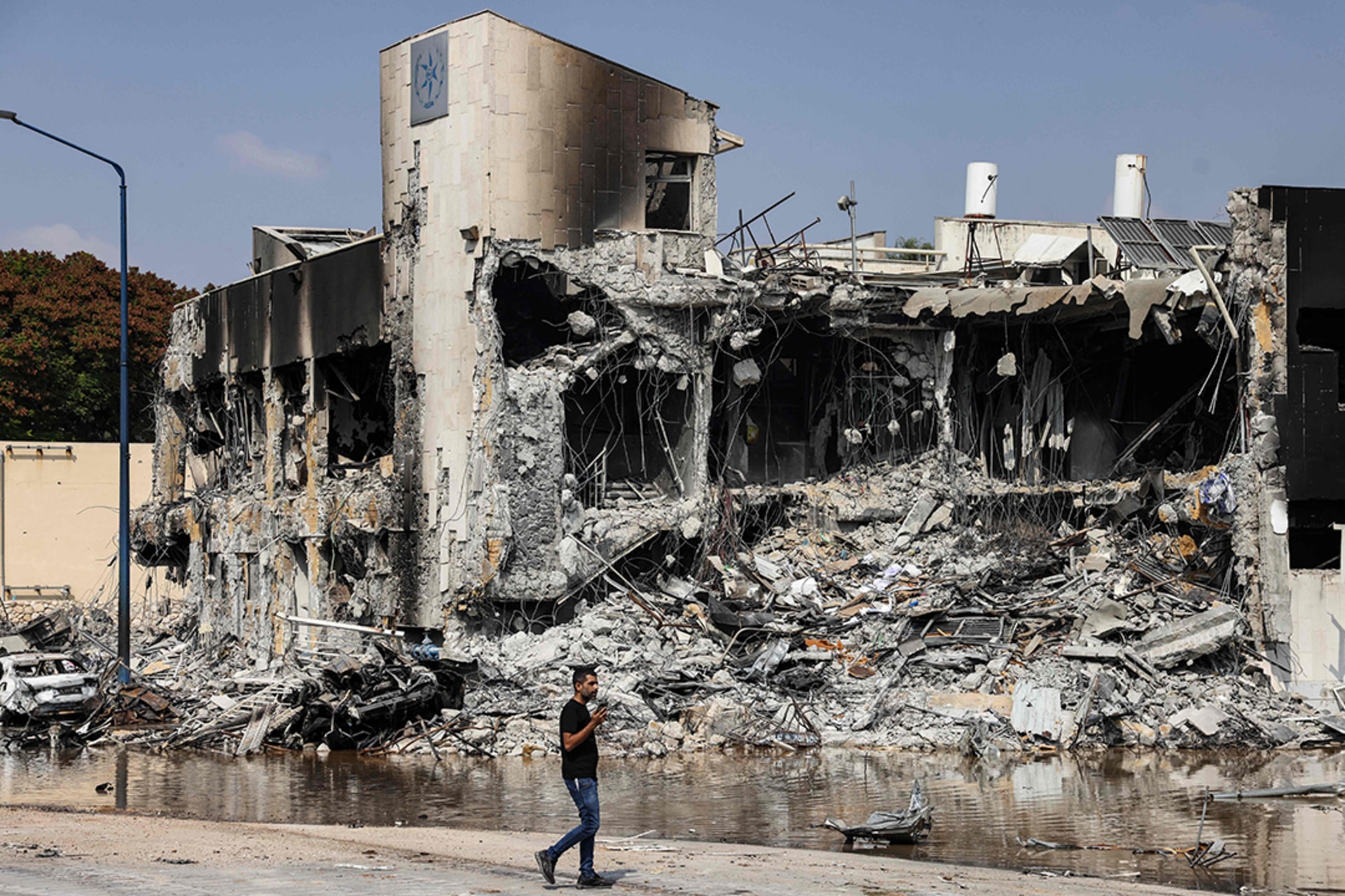 A man walks past a police station in Sderot, Israel, that was damaged during battles to dislodge Hamas militants stationed inside, on October 8, 2023. 
