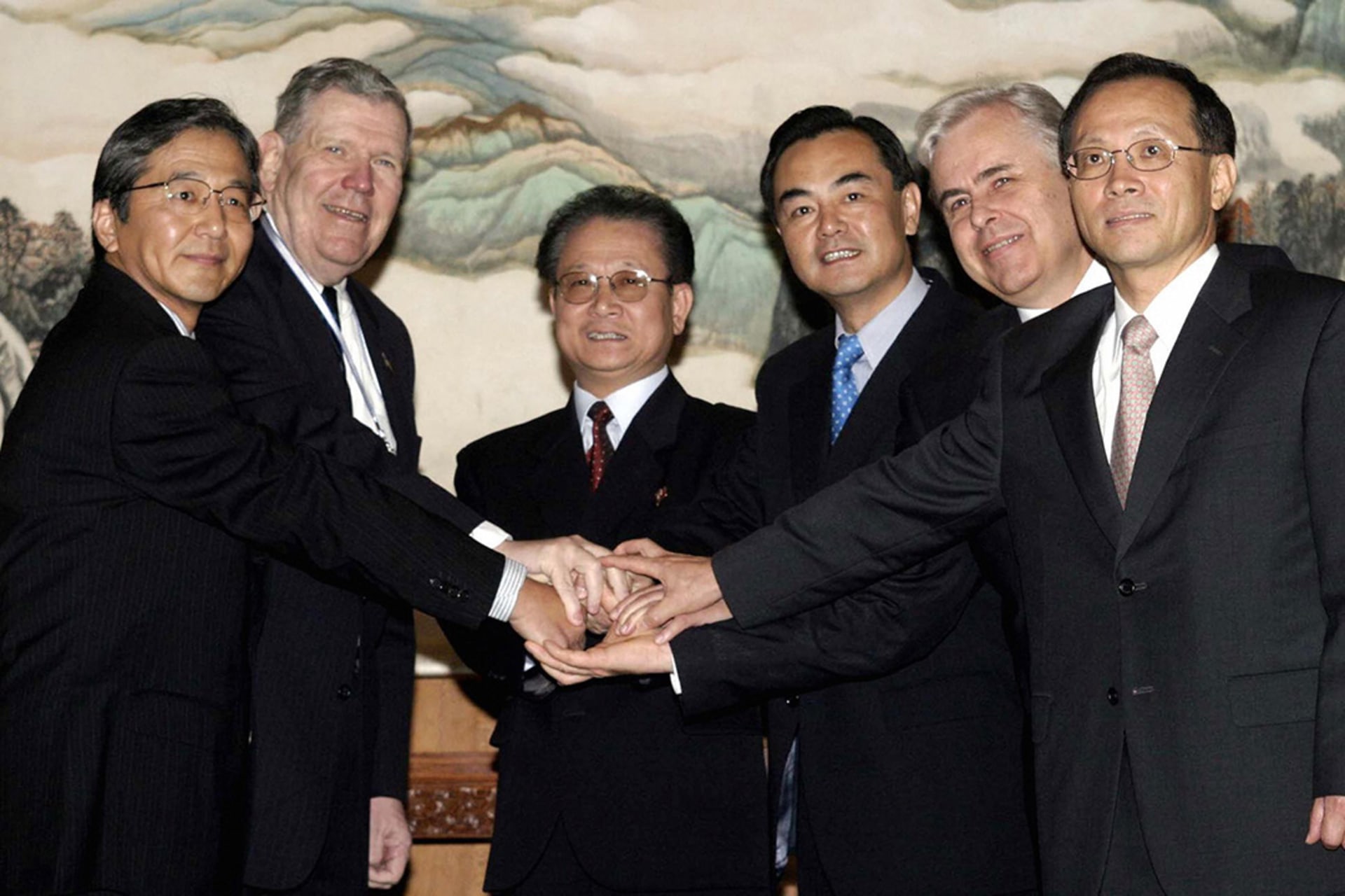 The heads of each of the six country delegations join hands before talks about North Korea’s nuclear crisis in Beijing. Ng Han Guan/AFP/Getty Images