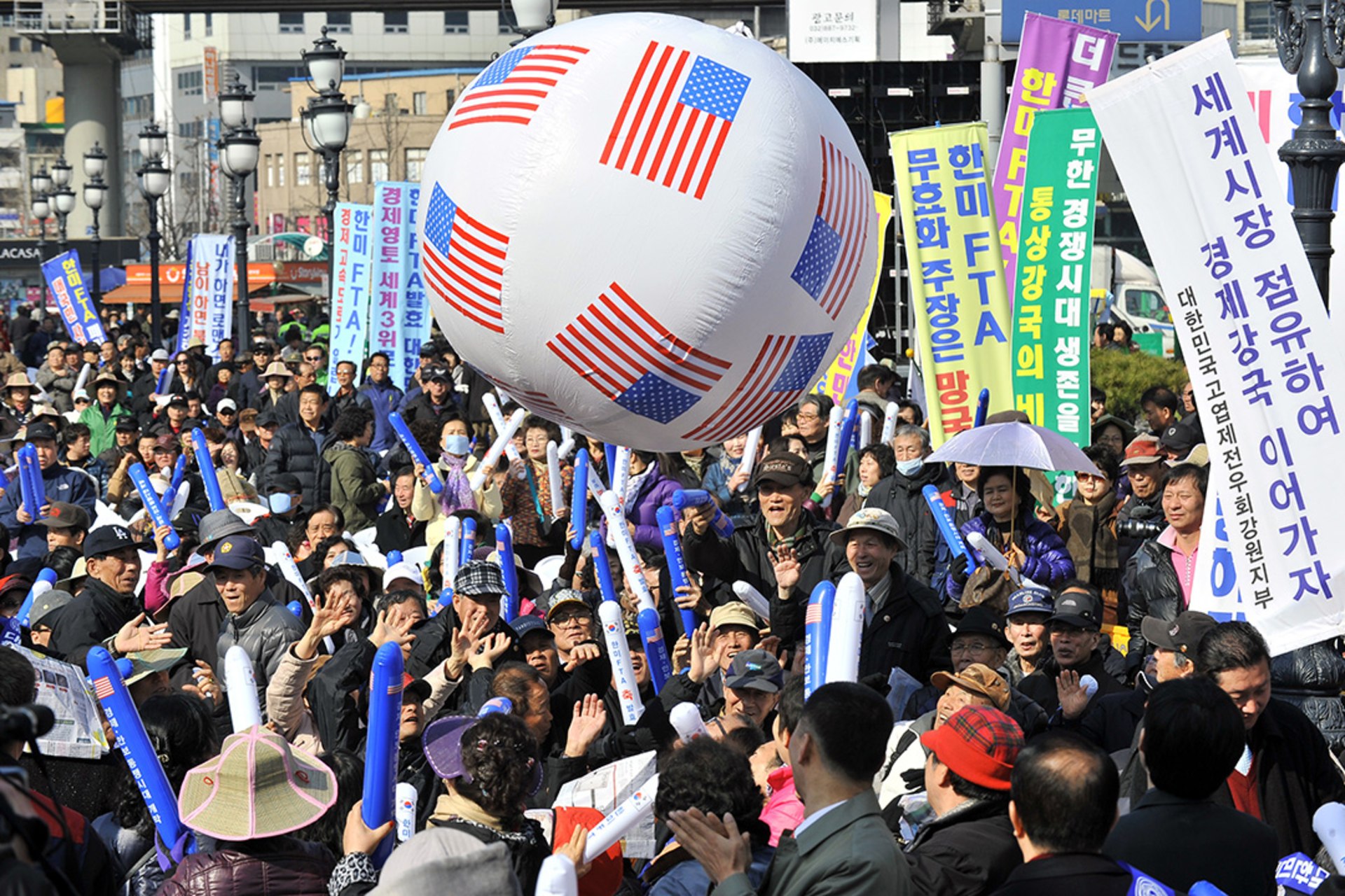 South Korean conservative activists raise a banner reading “let’s occupy the world market and become an economic power,” at a rally supporting the South Korea-U.S. free trade agreement in Seoul, South Korea. Jung Yeon-Je/AFP/Getty Images