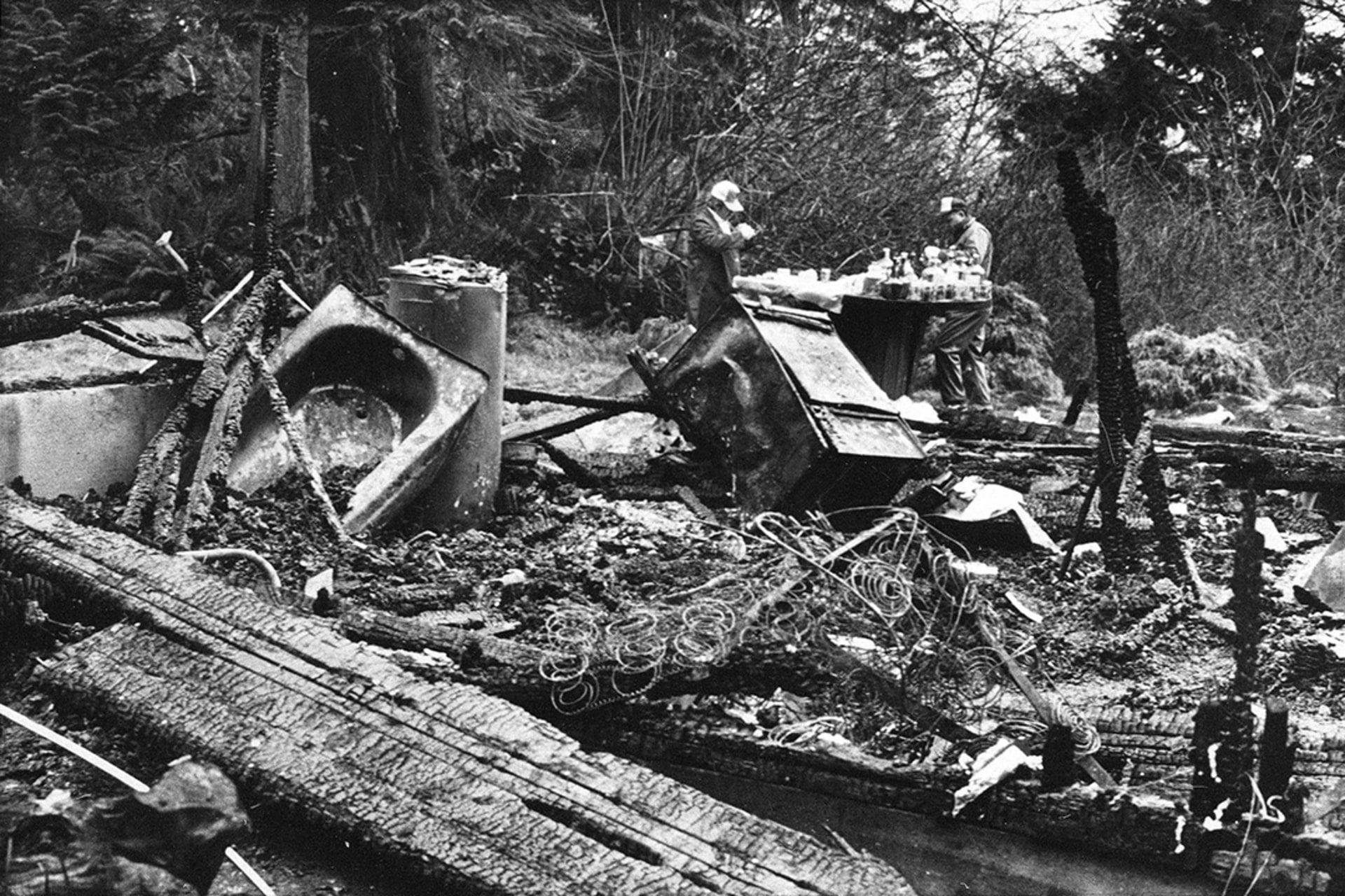 FBI agents sift through the ruins of the house where Robert J. Matthews, founder of the neo-Nazi group The Order, died in a fire amid a standoff with federal agents.