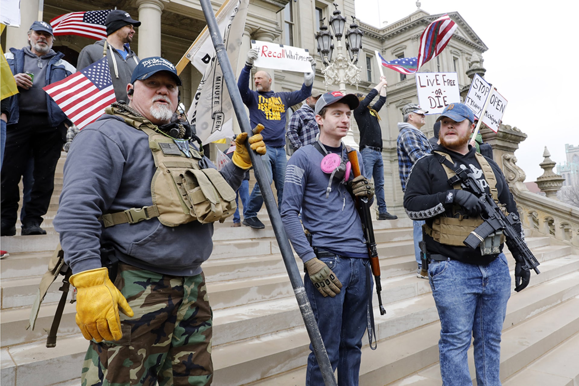 Armed civilian men stand on the steps of the Michigan State Capitol in Lansing, taking part in a protest against Governor Gretchen Whitmer’s expanded stay-at-home order during the COVID-19 pandemic.