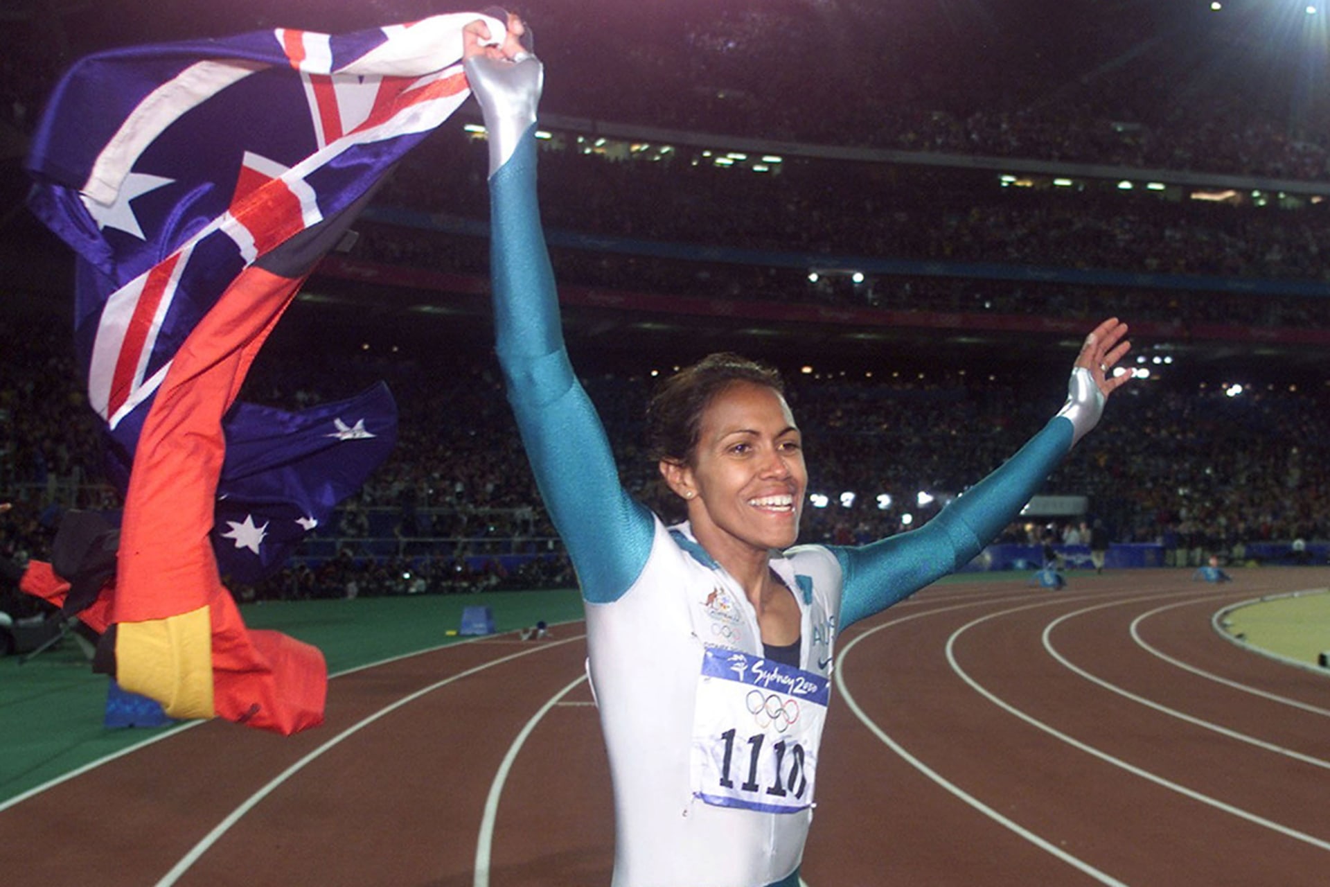 Cathy Freeman carries both the Aboriginal and the Australian flags during a victory lap in Sydney, Australia. Jerry Lampen/Reuters