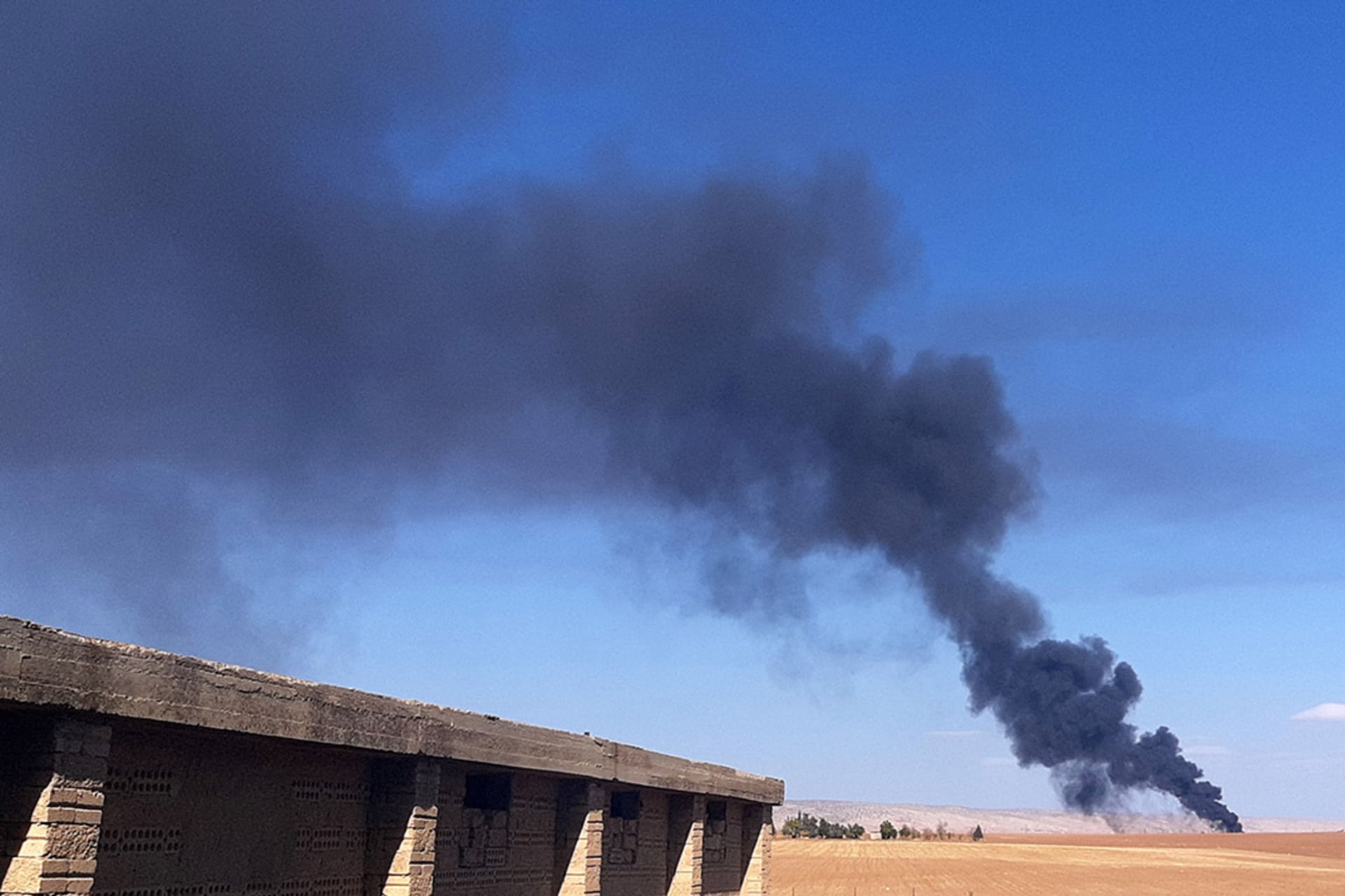Smoke rises from a field near the Syrian town of al-Qahtaniyah following reports of Turkish drone strikes in the area. 