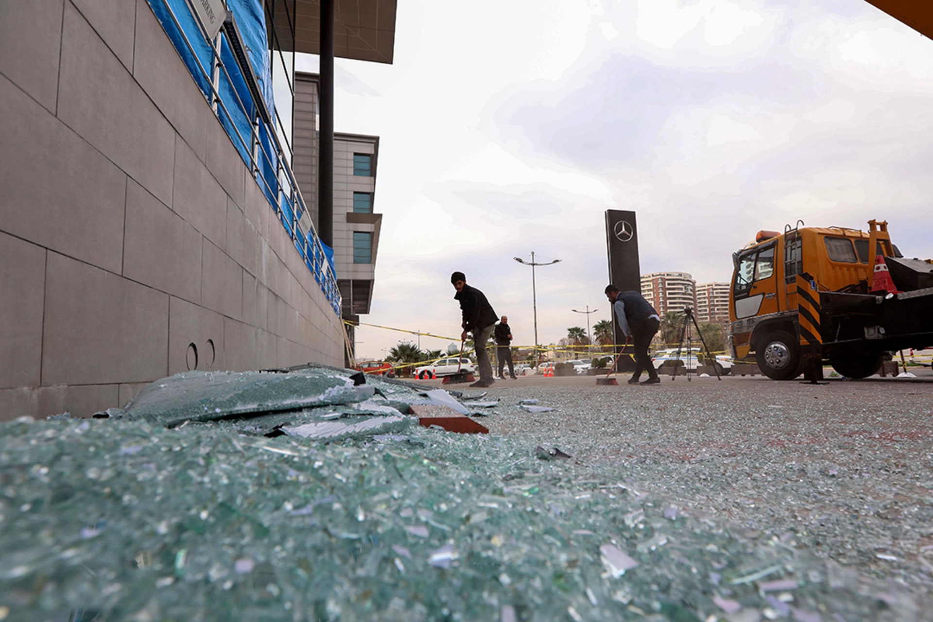 A worker sweeps shattered glass outside a damaged shop following a rocket attack in Erbil, the capital of Iraqi Kurdistan.