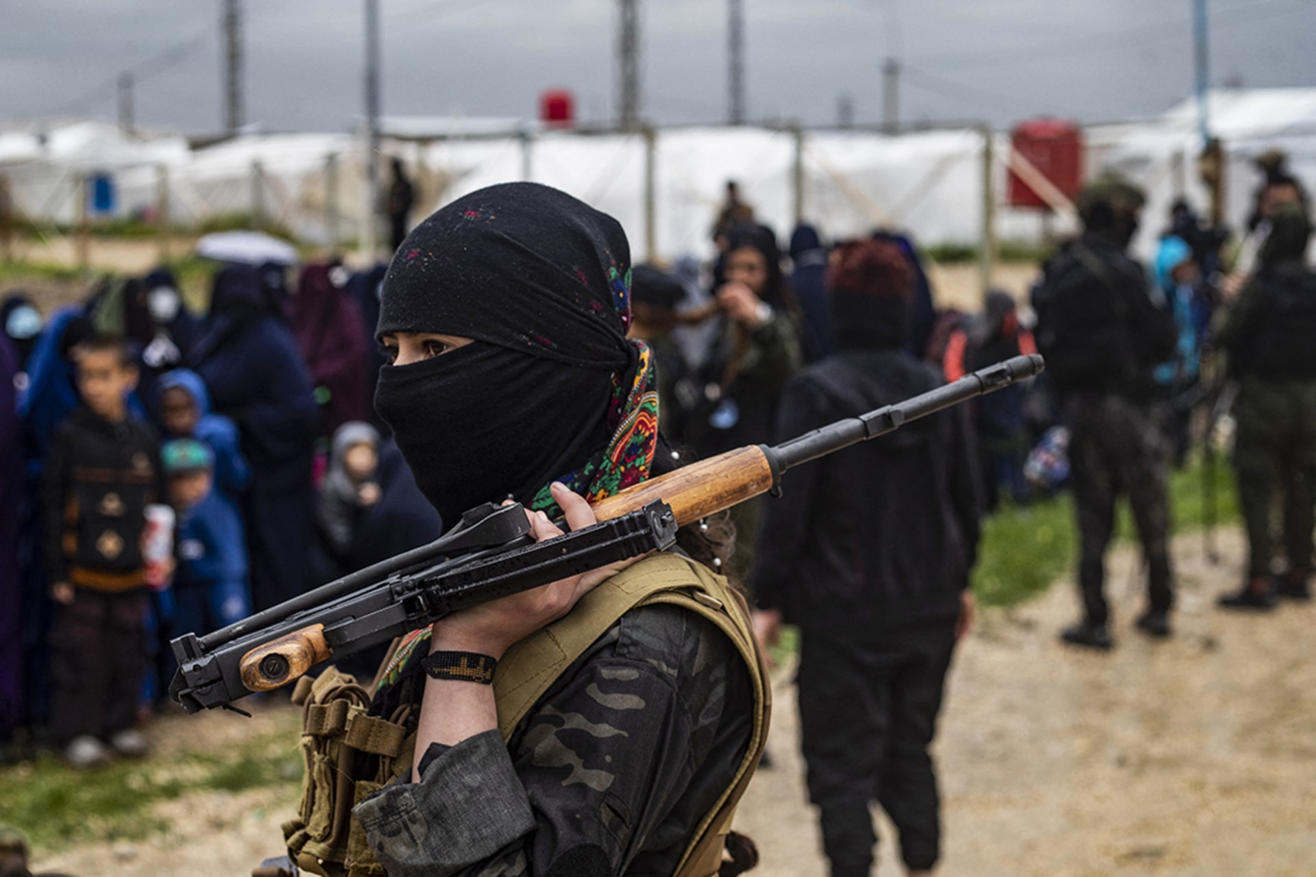 A woman fighter stands guard during a joint security operation for Syria’s Kurdish Internal Security Police Force. 
