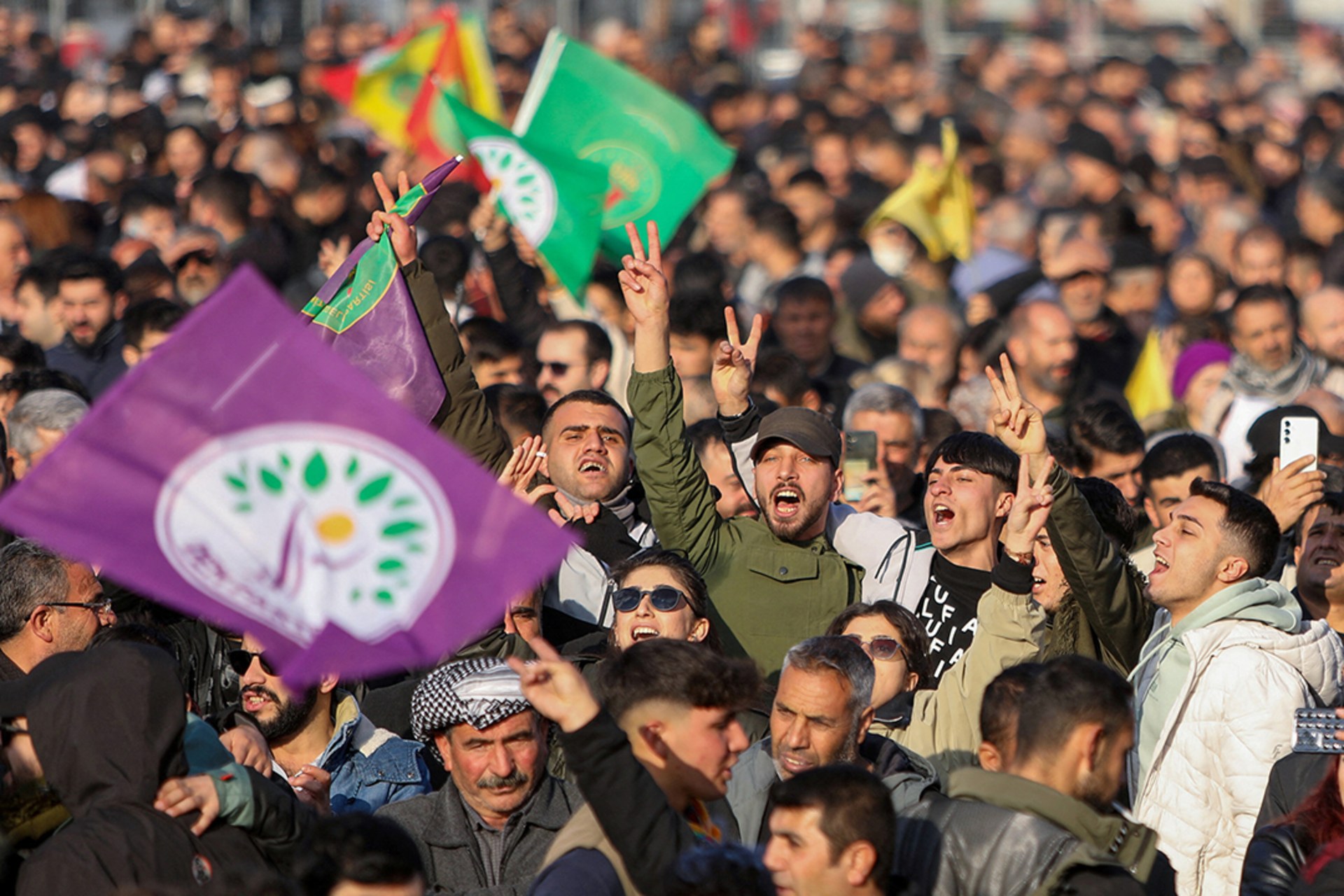 People flash V-signs as they gather to watch a televised press conference of the pro-Kurdish Peoples’ Equality and Democracy Party in Diyarbakir, Turkey.