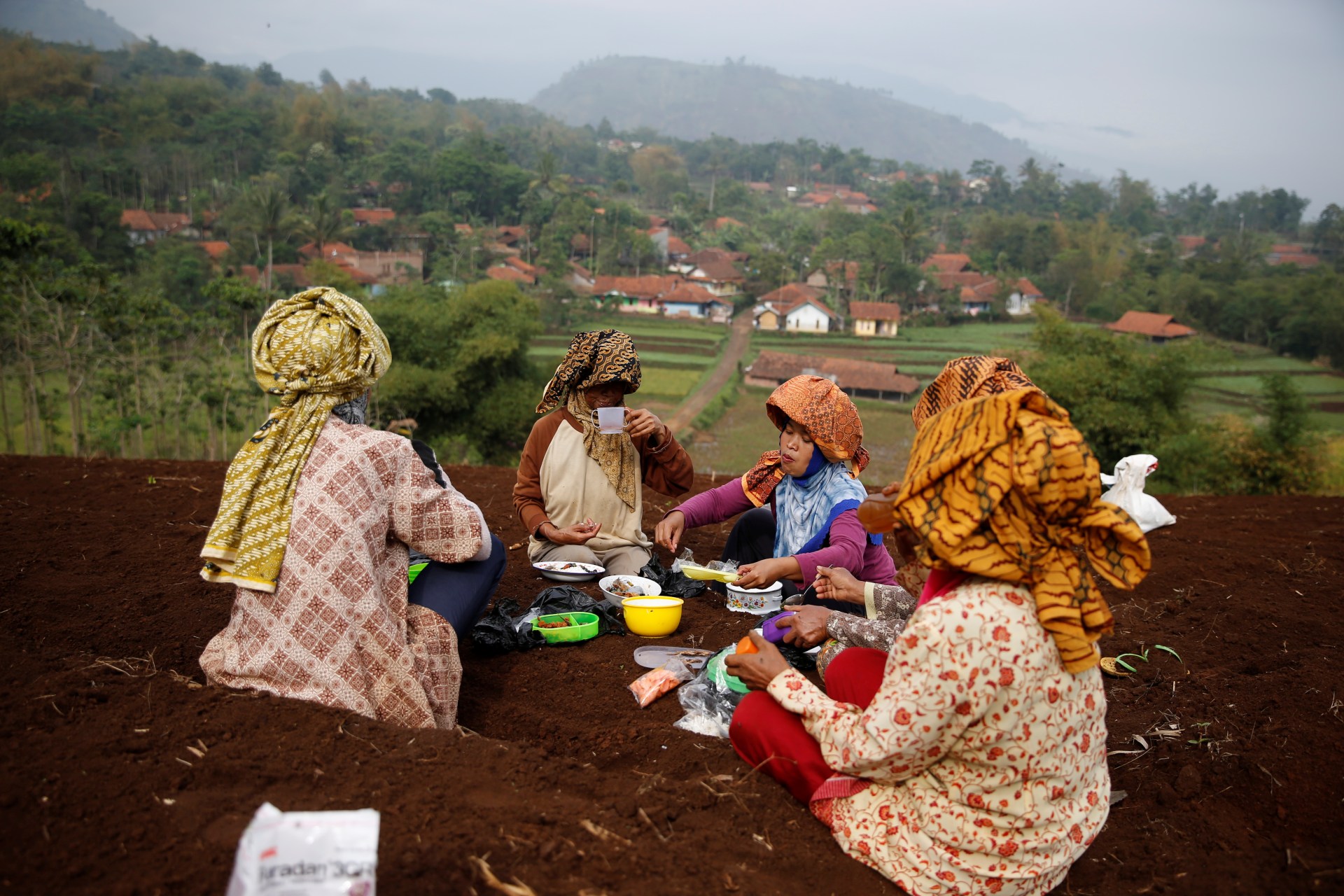 <p>Women workers eat lunch as they take a break from planting beans at Cikawao village in Majalaya, Indonesia, October 12, 2017.</p>
