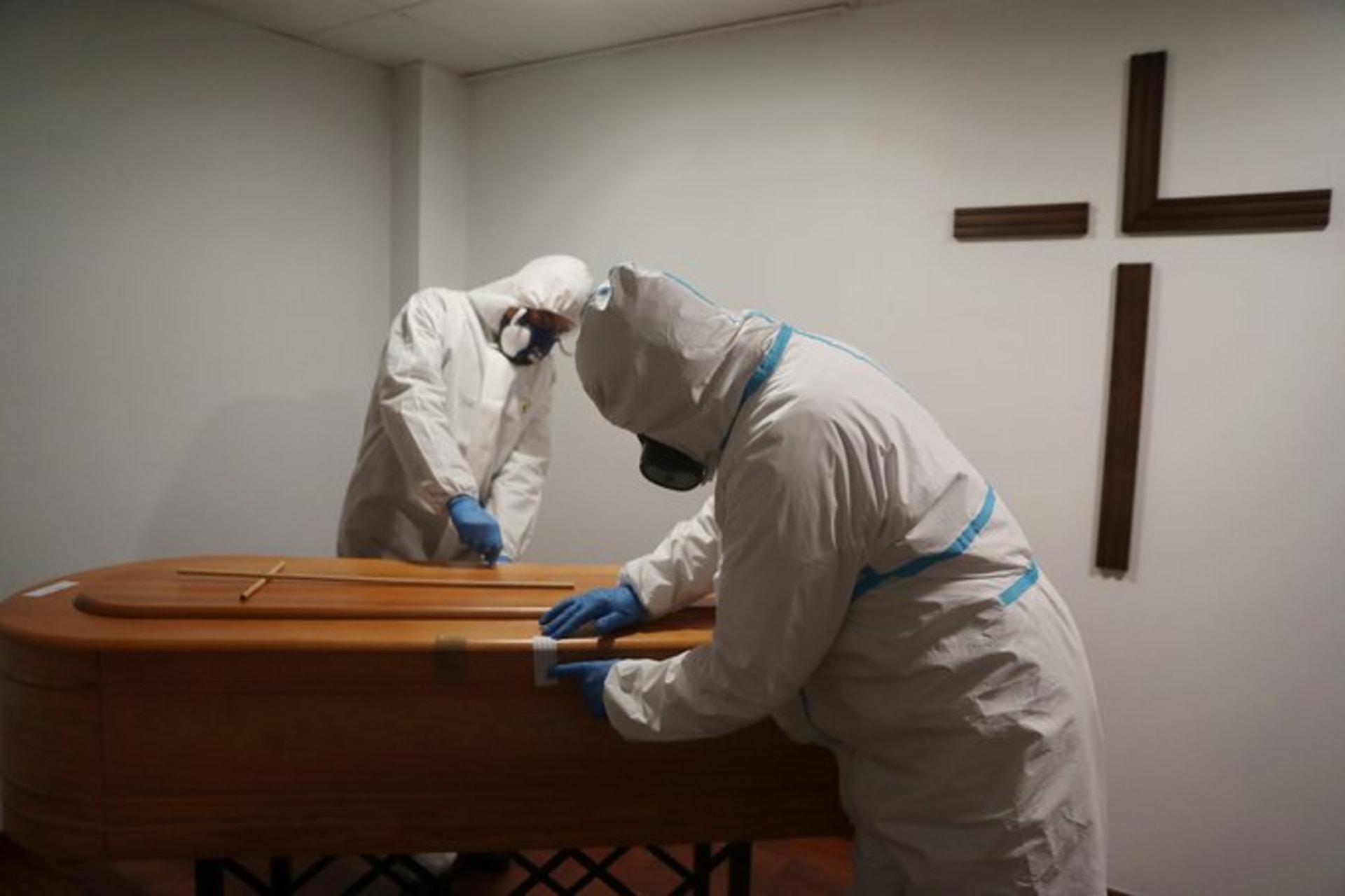 <p>SPAIN (L): Workers at a funeral home in Segovia tape a casket closed. Susana Vera/Reuters</p>
