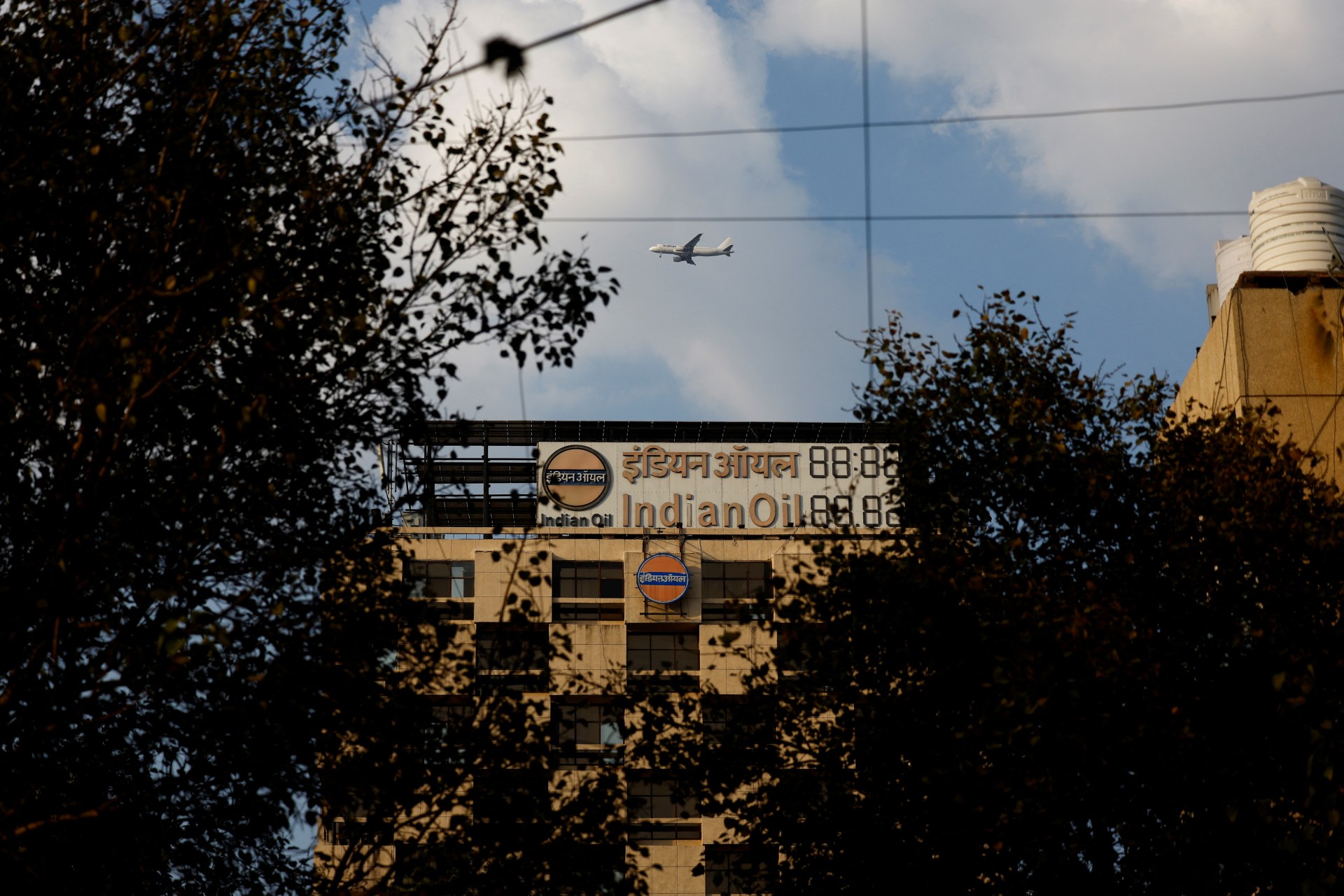 A plane flies over the Indian Oil Corporation Building in New Delhi