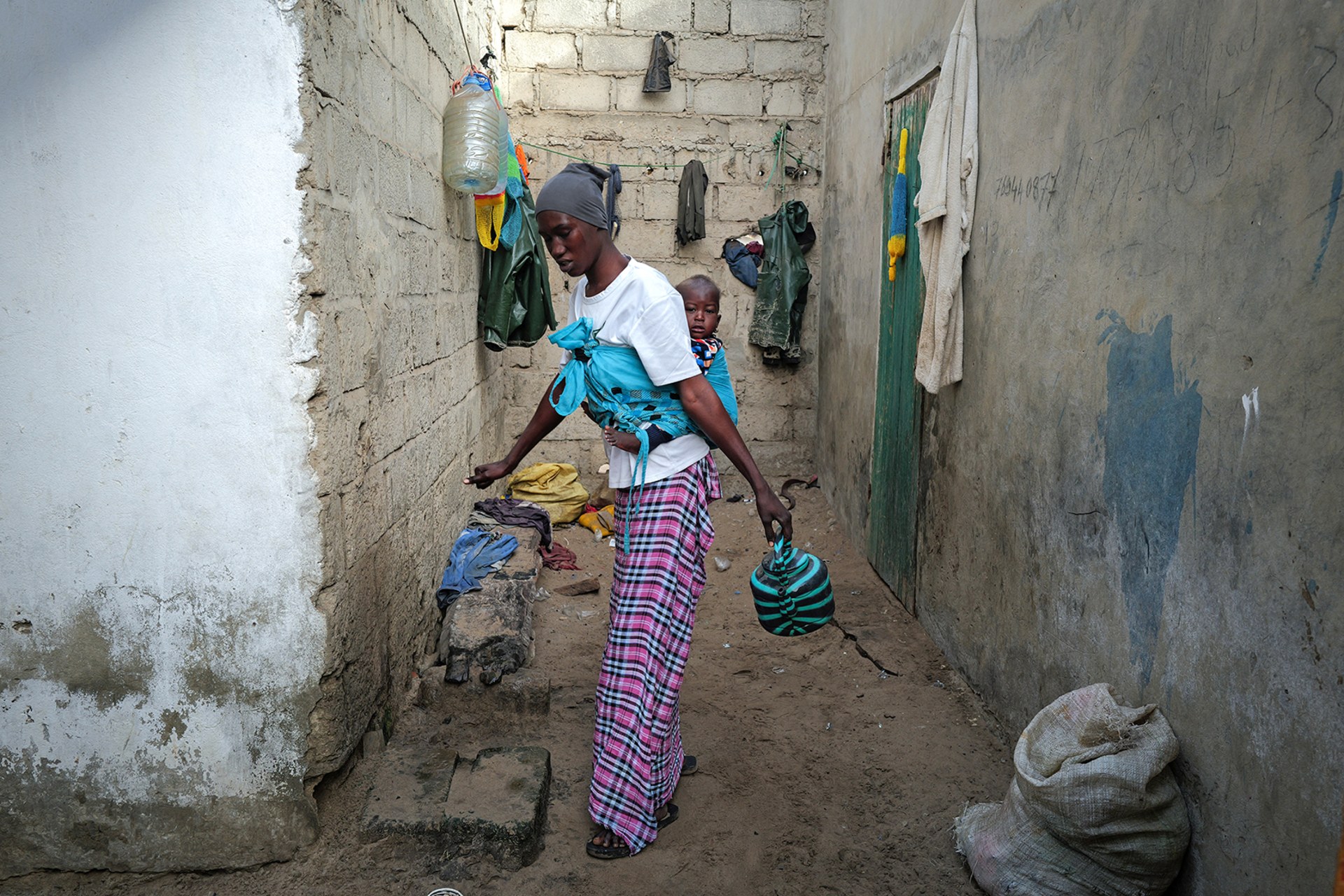 <p>FASS BOYE, SENEGAL: Months after a failed attempt to reach Europe by sea, an impoverished mother prepares for her morning wash outside her home. Zohra Bensemra/Reuters</p>