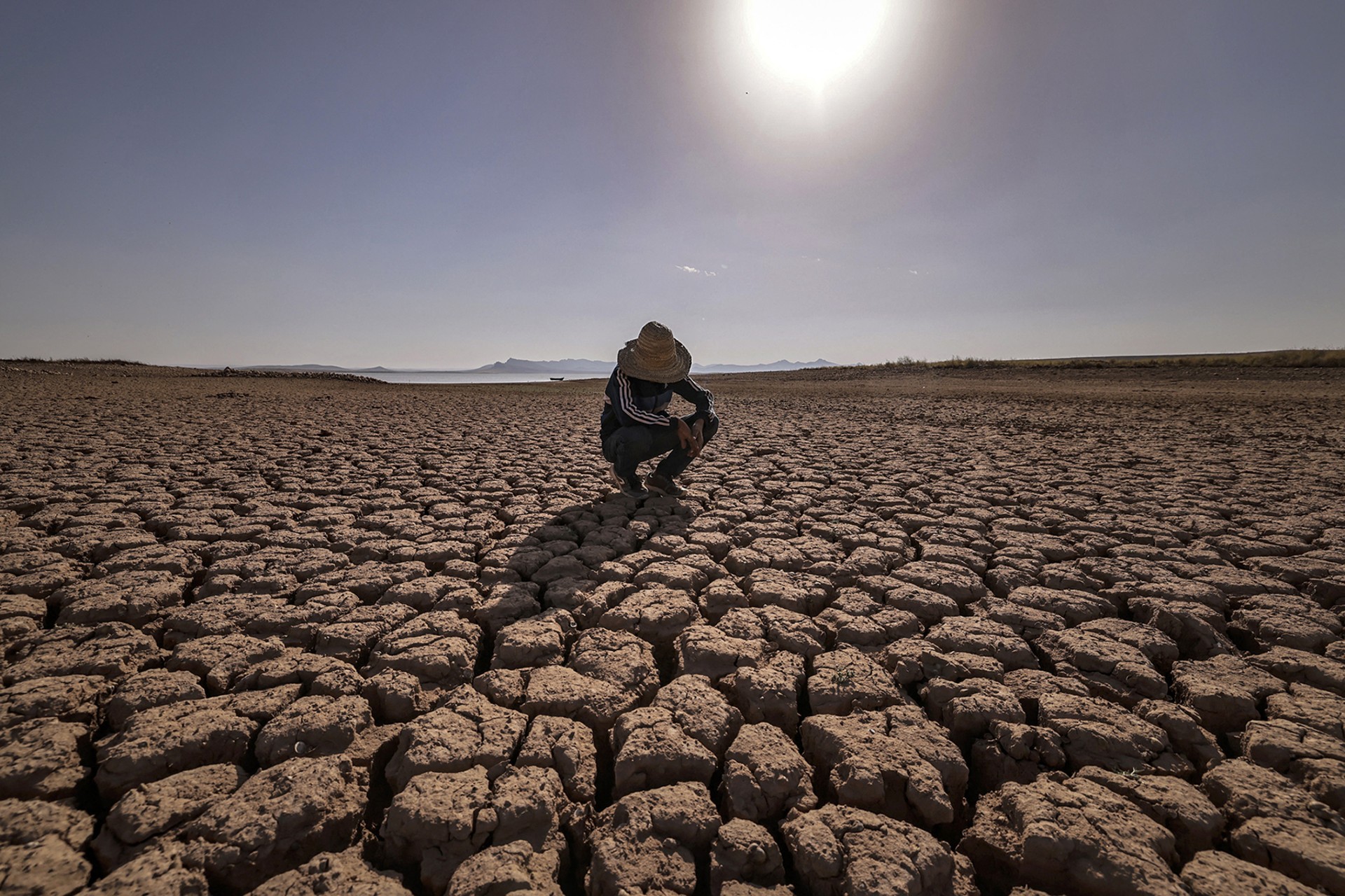 <p>OULED ESSI MASSEOUD, MOROCCO: A child crouches at al-Massira dam in August 2022 amid the country’s worst drought in at least forty years. Experts say that worsening effects of climate change could increasingly contribute to refugee flows. Fadel Senna/AFP/Getty Images</p>