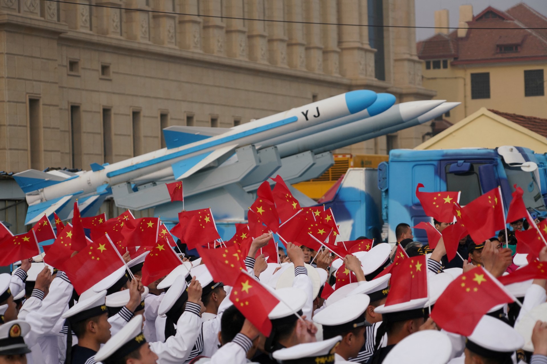 Chinese People's Liberation Army (PLA) Navy soldiers wave Chinese flags next to a model of a military vehicle carrying anti-ship missiles, during an event marking the 70th anniversary of the founding of the Chinese People's Liberation Army Navy, April 23, at the navy museum in Qingdao, Shandong province, China, April 13, 2019. REUTERS/Stringer